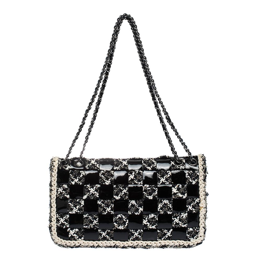 We are in utter awe of this flap bag from Chanel as it is appealing in a surreal way. Exquisitely crafted from tweed and patent leather in a unique chessboard style, it bears their signature label on the nylon-lined interior and the iconic CC