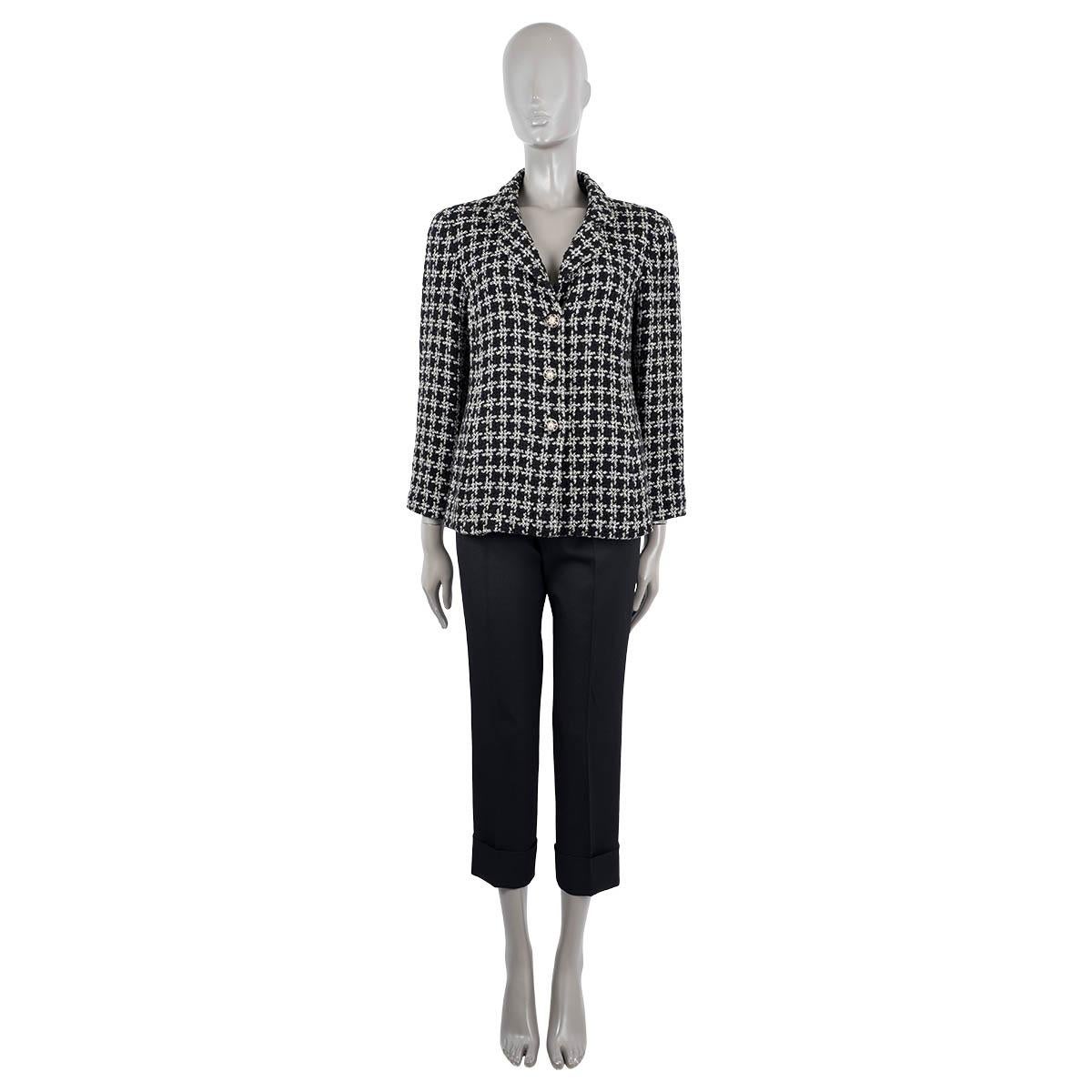 100% authentic Chanel houndstooth tweed jacket in black and white cotton (54%) and silk (46%). Features CC embossed pearl and leather woven chain buttons and a button flap in the back. Lined in silk (100%). Has been worn and is in excellent