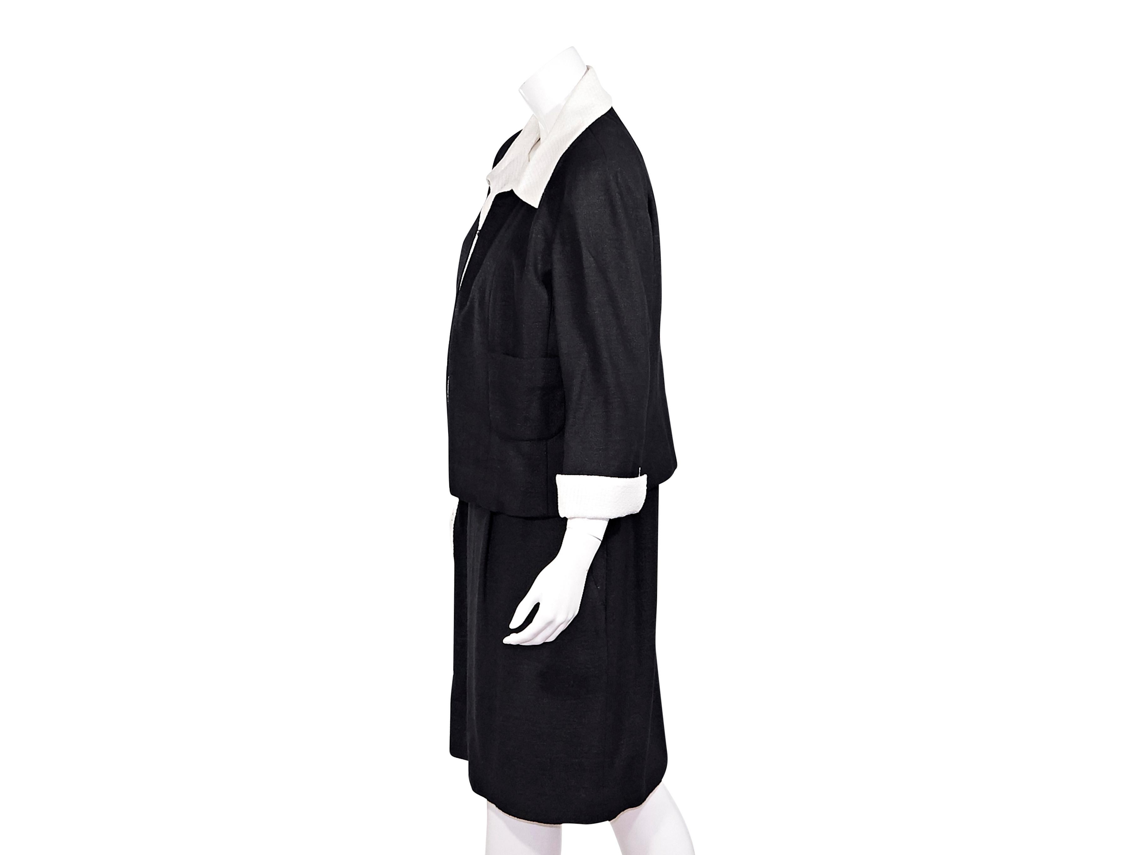 Product details:  Black and white textured jacket and dress set by Chanel.  From the Spring/Summer 2009 collection.  Spread collar.  Concealed hook-front closure.  Waist patch pockets.  Matching shift dress.  Accented with a bow.  Scooopneck. 