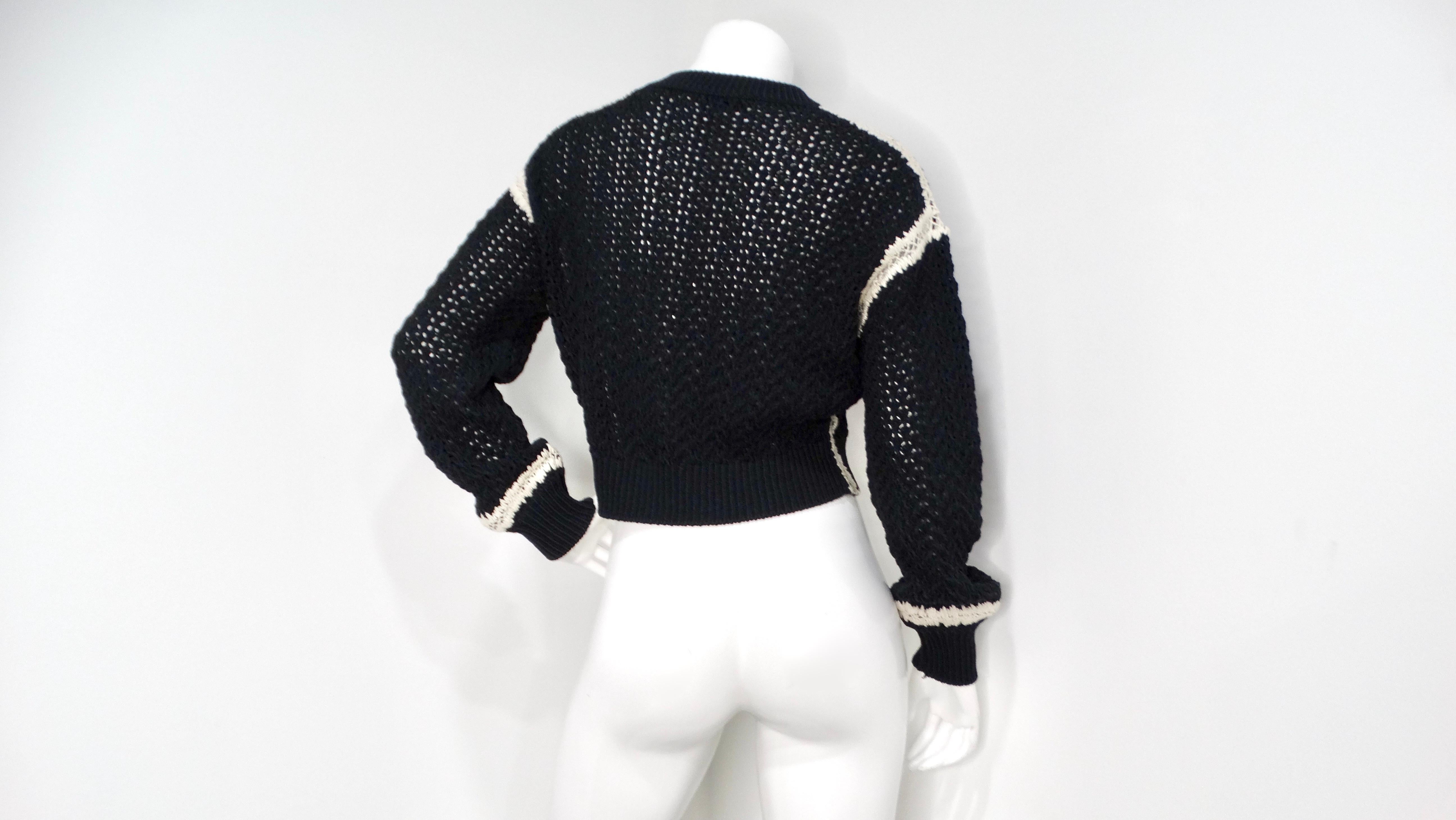 Elevate your wardrobe with this chic Chanel cropped sweater. Crafted from a luxurious blend of cotton and silk, the monochrome knit offers a timeless yet modern aesthetic. The classic black palette with white detailing makes it incredibly versatile.