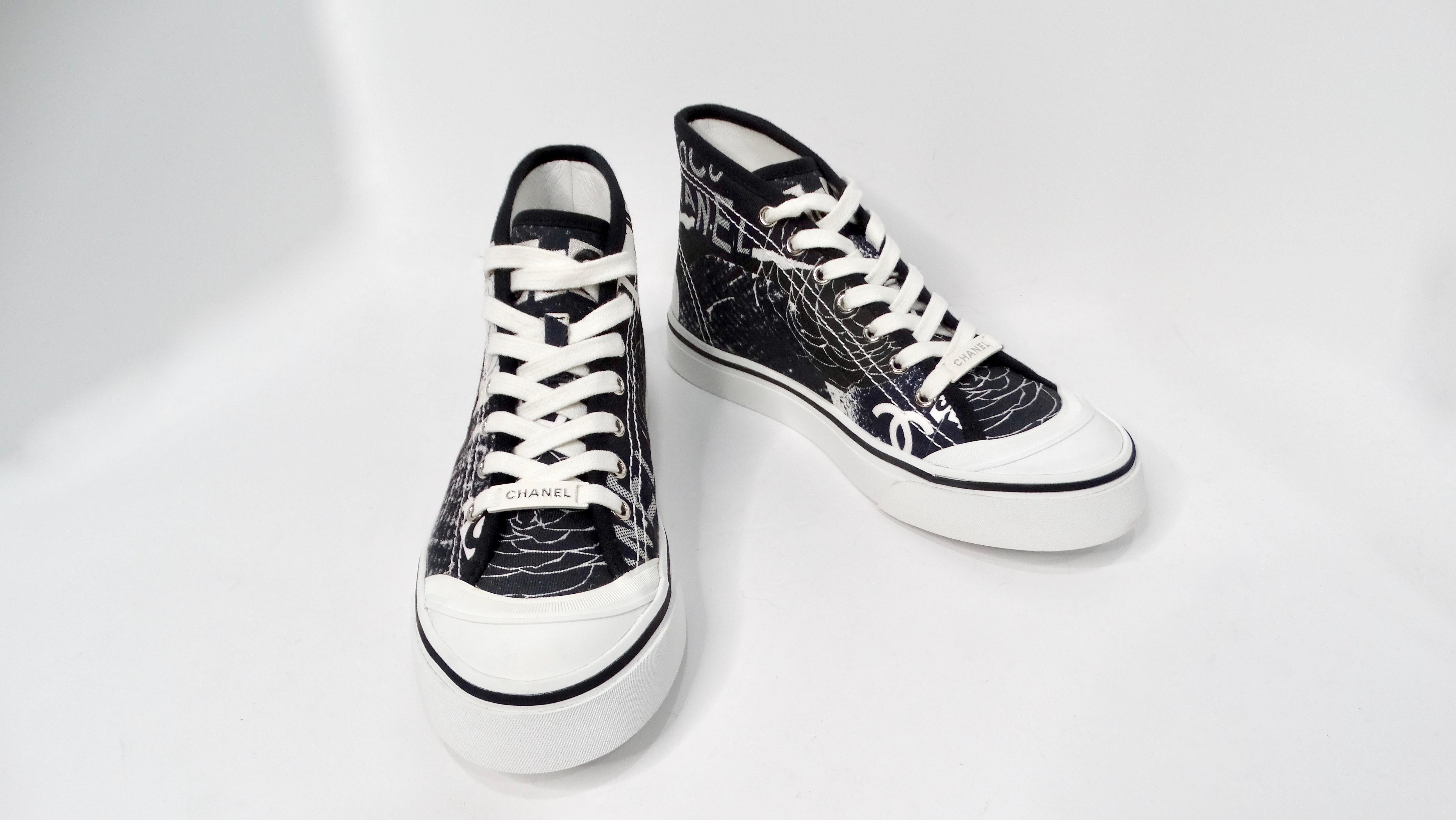 Step into the world of luxury and style with the Chanel Black & White Printed Fabric High-Top Camellia Sneakers. Designed to make a statement, these sneakers feature a sleek black fabric exterior adorned with elegant white camellia prints,