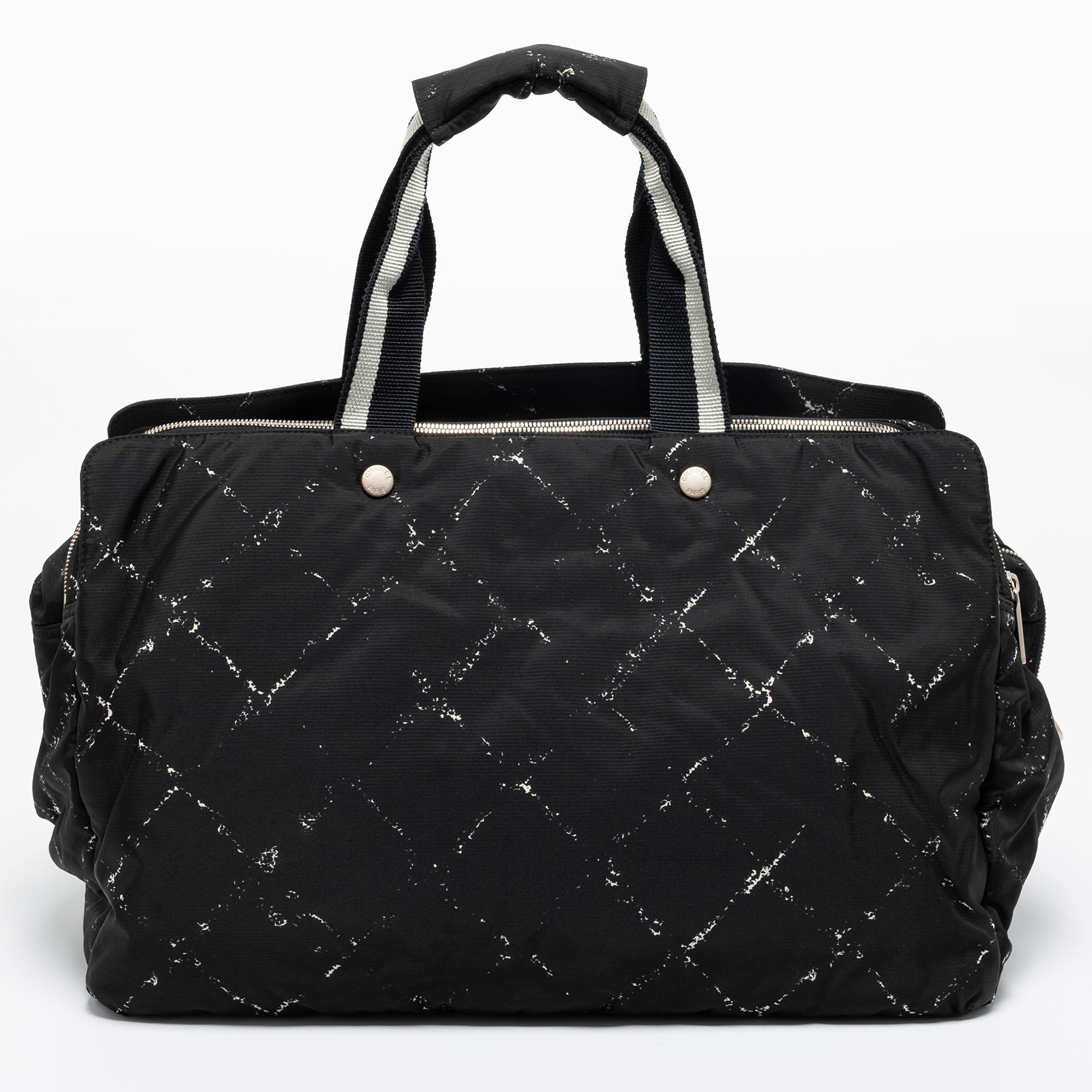 This Travel Line Duffel bag by Chanel will comfortably hold all your daily necessities. Crafted from fabric and nylon, it has a quilted print, top handles, and a shoulder strap. Perfect for weekend getaways!

Includes: Original Dustbag, Detachable