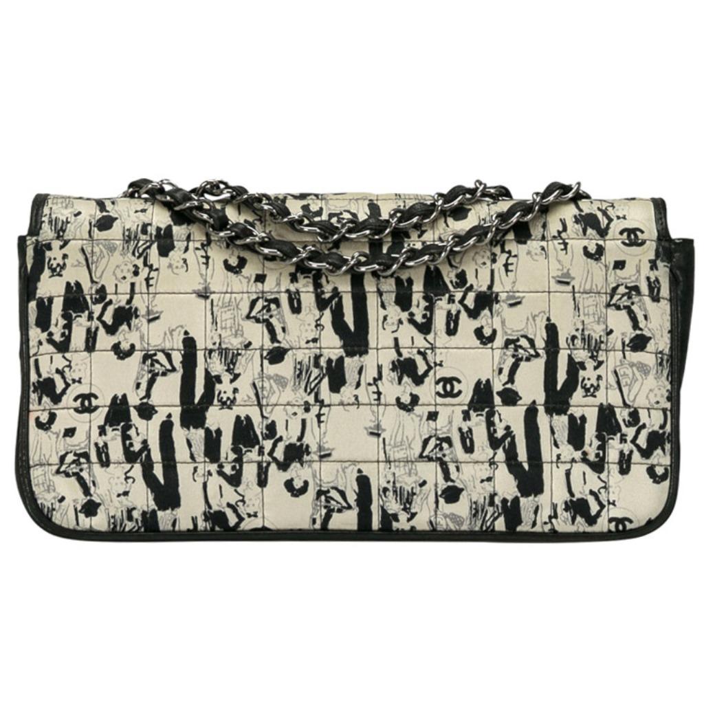 Spacious and captivating, this Coco Mademoiselle flap bag is from Chanel. It has been crafted from black and white satin with leather trims and features Coco Chanel's print all over along the signature CC logos. It is equipped with a single