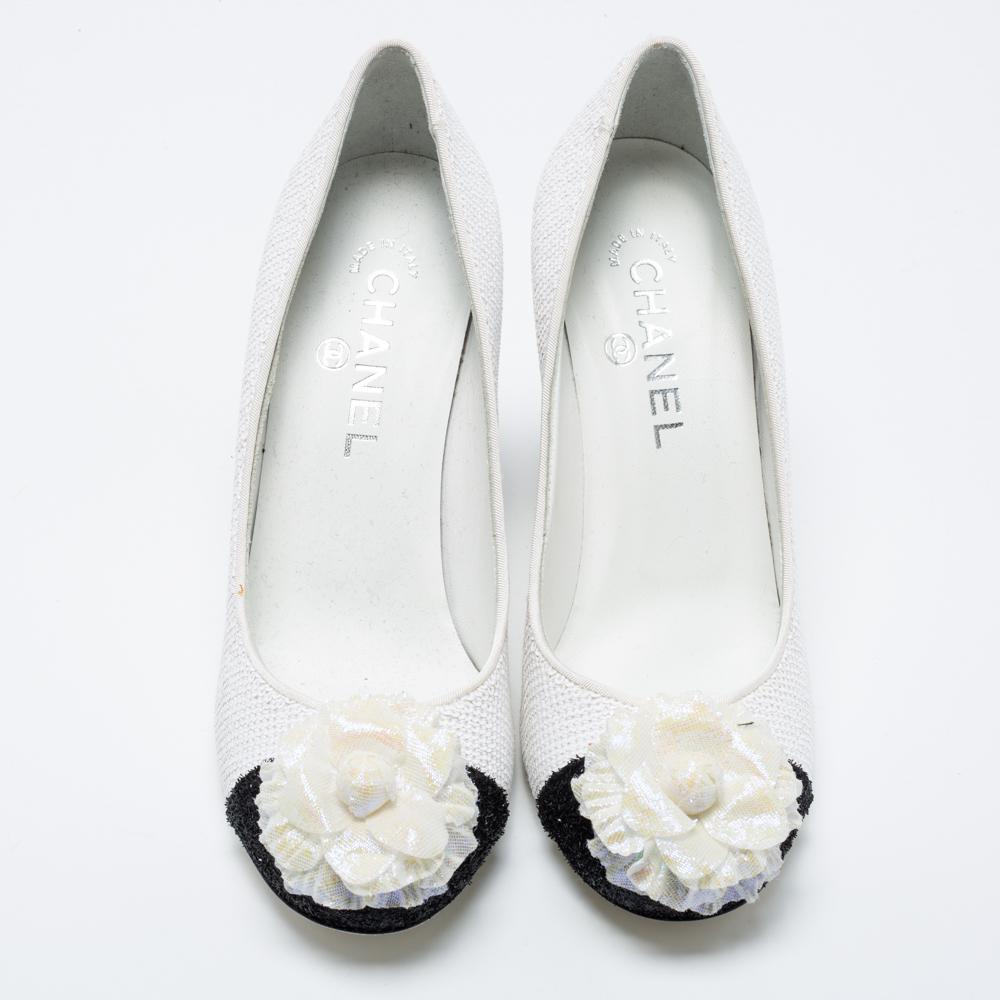 From the House of Chanel come these pumps to elevate the look of your attire. They are crafted using white-black sequins on the exterior. They showcase a Camellia applique on toes, a slip-on style, and block heels. Pair these Chanel pumps with your
