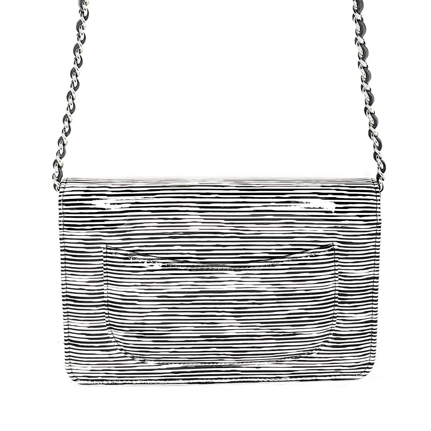 From the Resort 2014 Collection; Chanel Wallet on Chain Striped Patent, crafted from black and white striped printed patent Calfskin leather, features woven-in leather chain strap, interlocking CC logo on its flap, and silver-tone hardware. Its