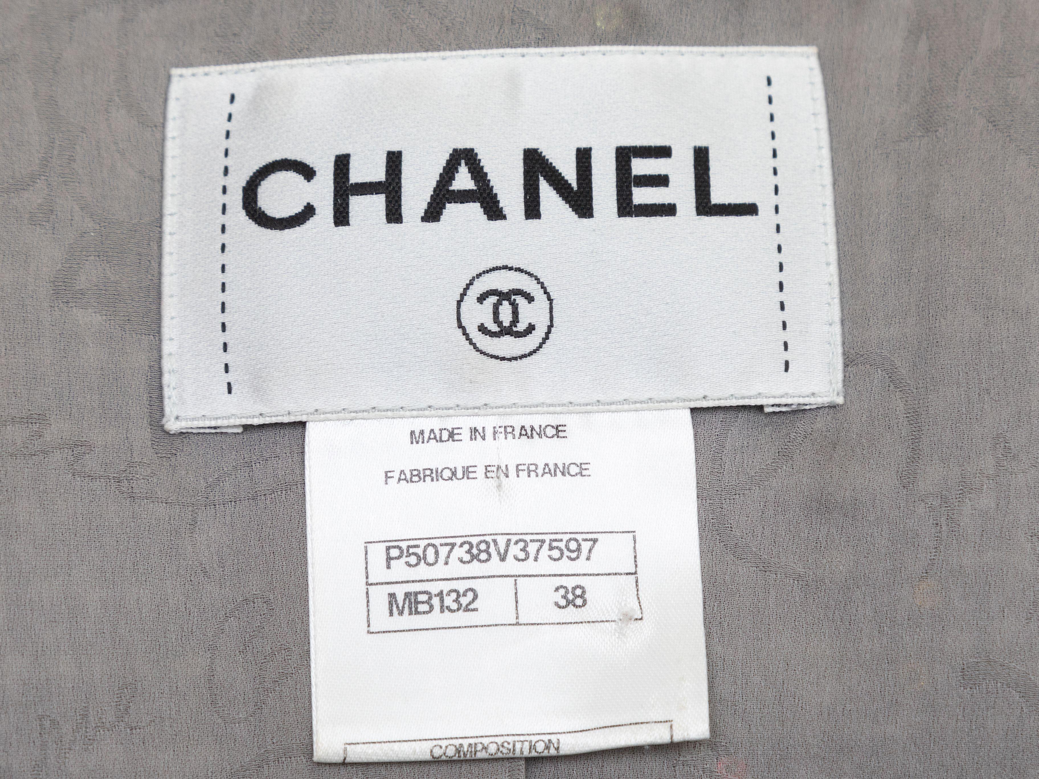 Produktdetails: Schwarze und weiße Tweed-Jacke von Chanel. Durchgehend Paillettenverzierungen. Rundhalsausschnitt. Die Taschen mit Klappen an der Büste sind mitklappbar. In der Mitte der Vorderseite befinden sich Knopfleisten mit