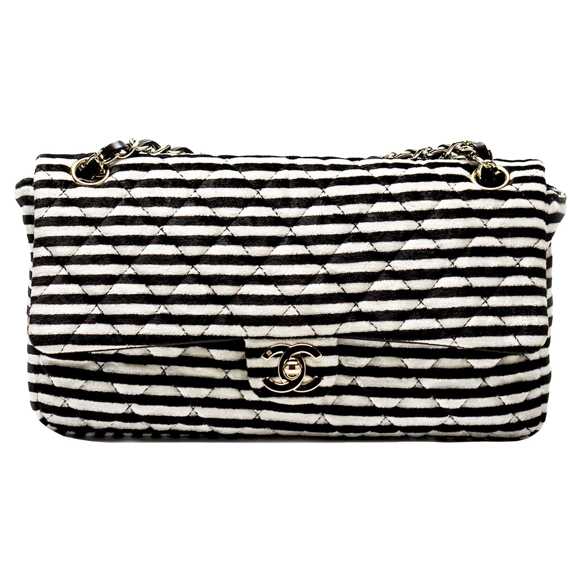 Chanel velour black and white striped flap

2006 {VINTAGE 18 Years}
Silver Hardware
Classic interwoven lambskin chain
Three pearl charm detail on strap
CC turnlock closure
Black lambskin lined flap
Nylon lined interior
6