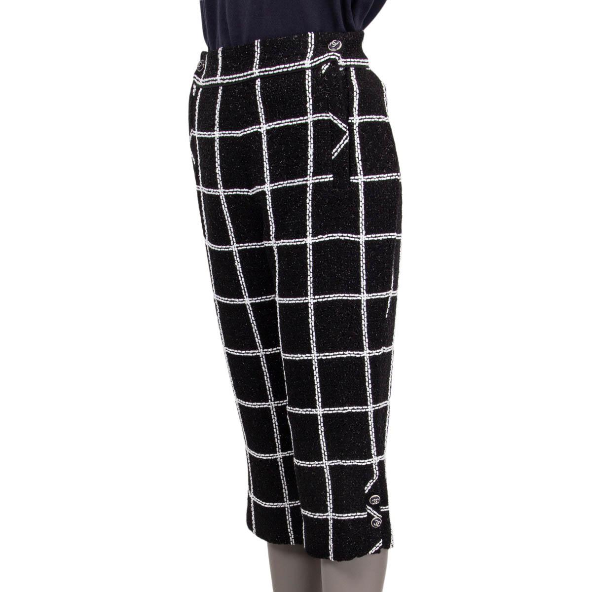 100% authentic Chanel check 3/4 tweed pants in black and white viscose (74%), polyamide (9%), polyester (9%), acrylic (4%), cotton (3%) and wool (1%). Open with two 'CC' buttons and two concealed zippers on the front. Lined in black silk (87%) and