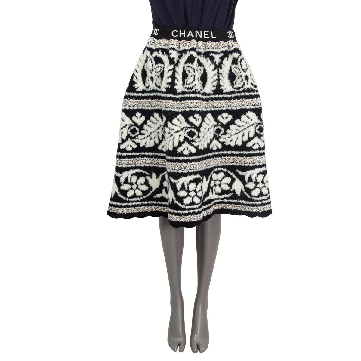 100% authentic Chanel flared chunky knit below-length skirt in black, off-white, orange and blue wool (91%), polyamide (8%) and cashmere (1%). Opens with a concealed zipper and a hook on the side. Unlined. Has been worn and is in excellent