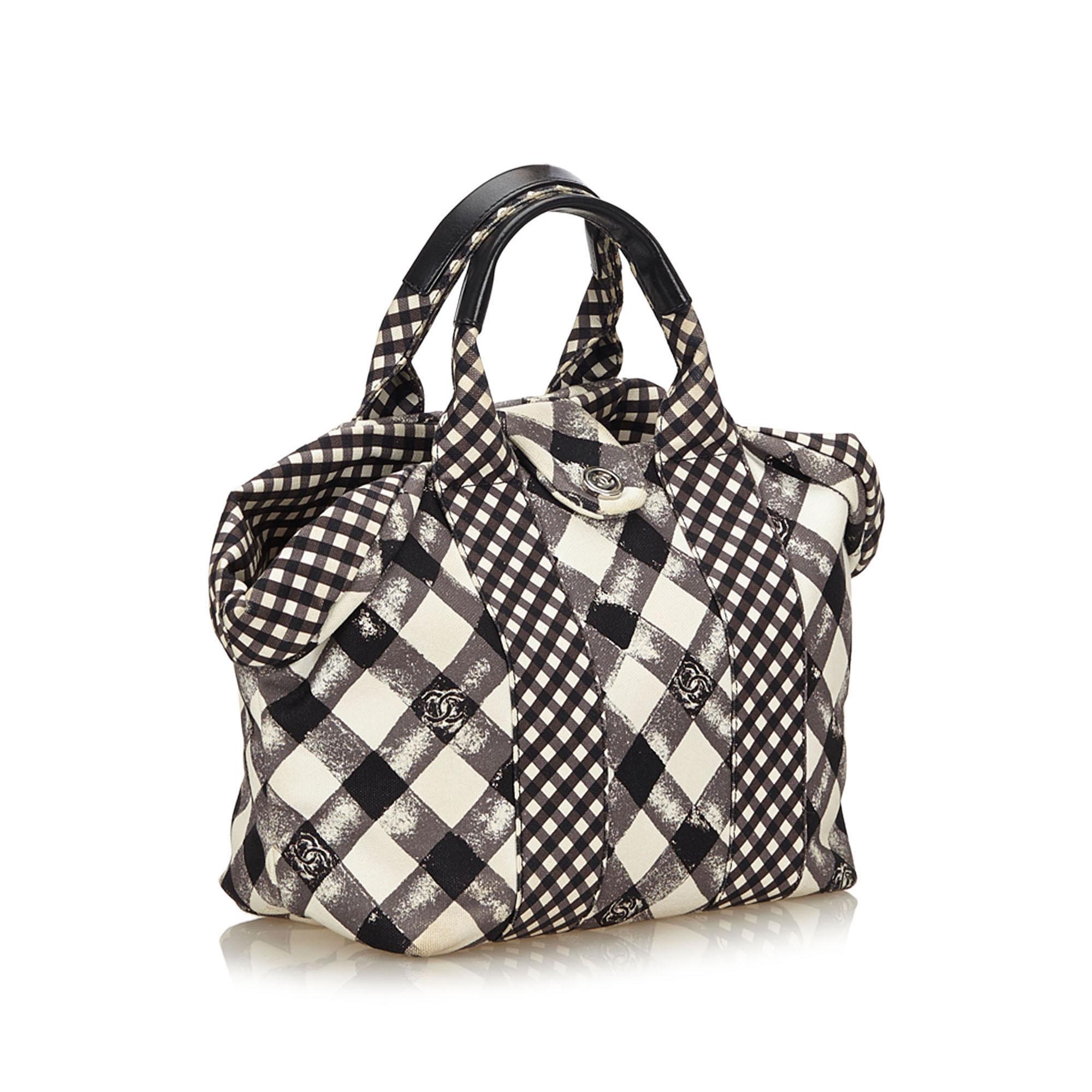 This tote bag features a gingham canvas body, rolled leather handles, open top, and interior zip and open pockets. It carries as B+ condition rating.

Inclusions: 
Dust Bag

Dimensions:
Length: 23.00 cm
Width: 21.00 cm
Depth: 13.00 cm
Hand Drop: