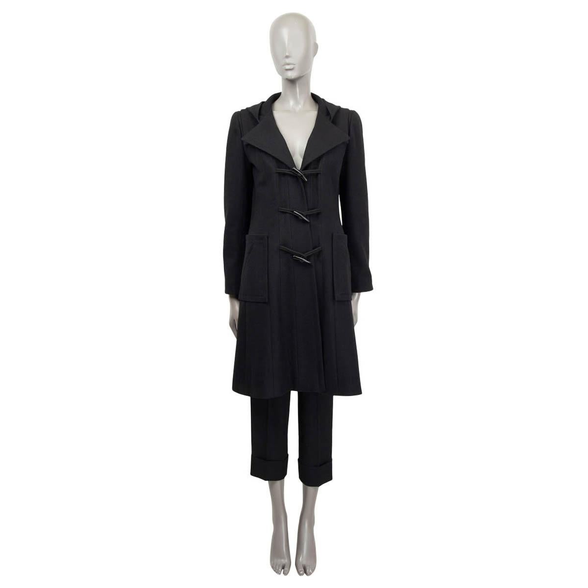 100% autentico montgomery con cappuccio Chanel in lana nera (100%). Caratterizzato da chiusura ad alamari, cappuccio, due tasche applicate sul davanti e schiena a pieghe. Foderato in seta (100%). È stato indossato ed è in condizioni