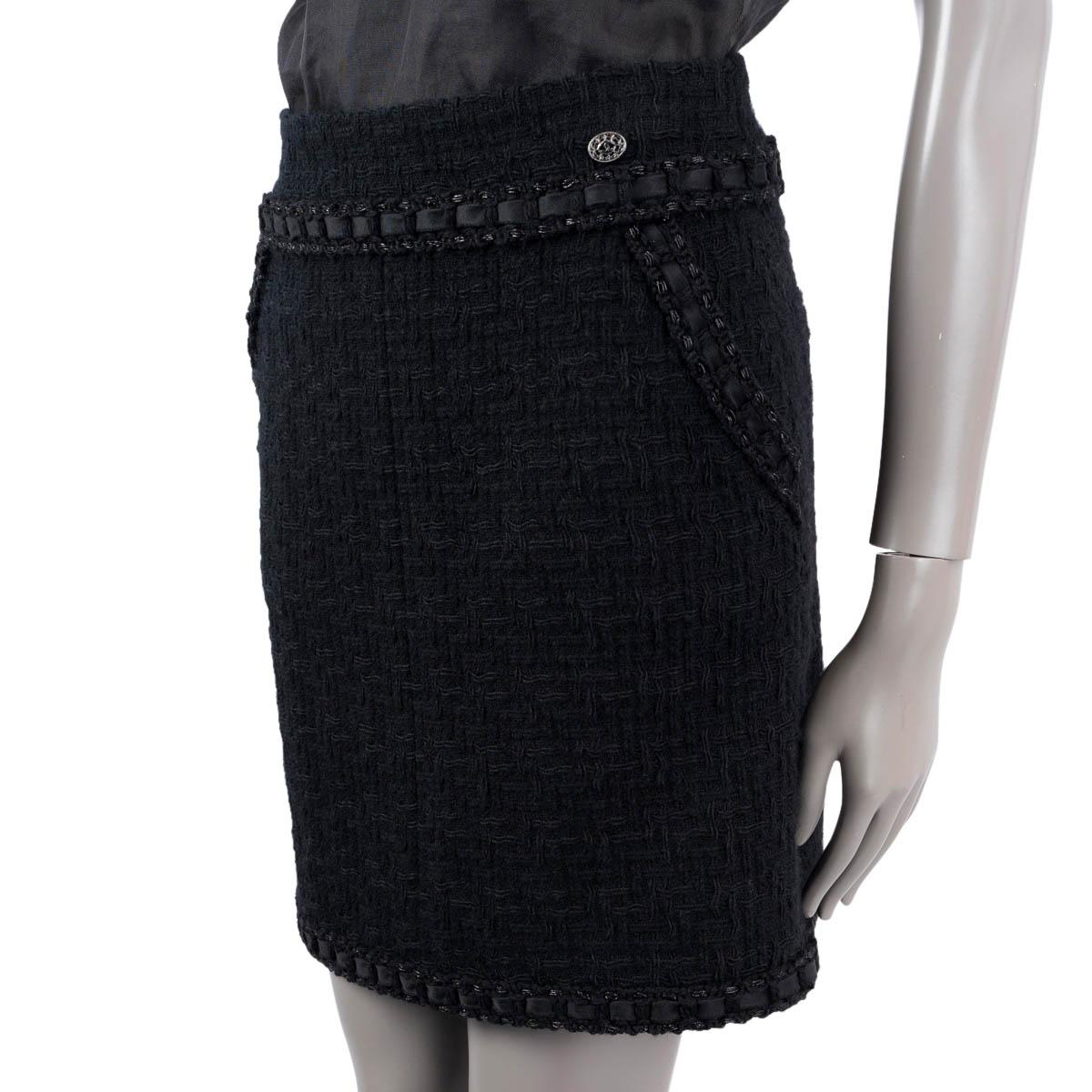 100% authentic Chanel tweed mini skirt in black wool (100%). Features a satin ribbon trim and two slant pockets on the front. Opens with a concealed zipper and a hook in the back. Lined in silk (100%). Has been worn and is in excellent condition.