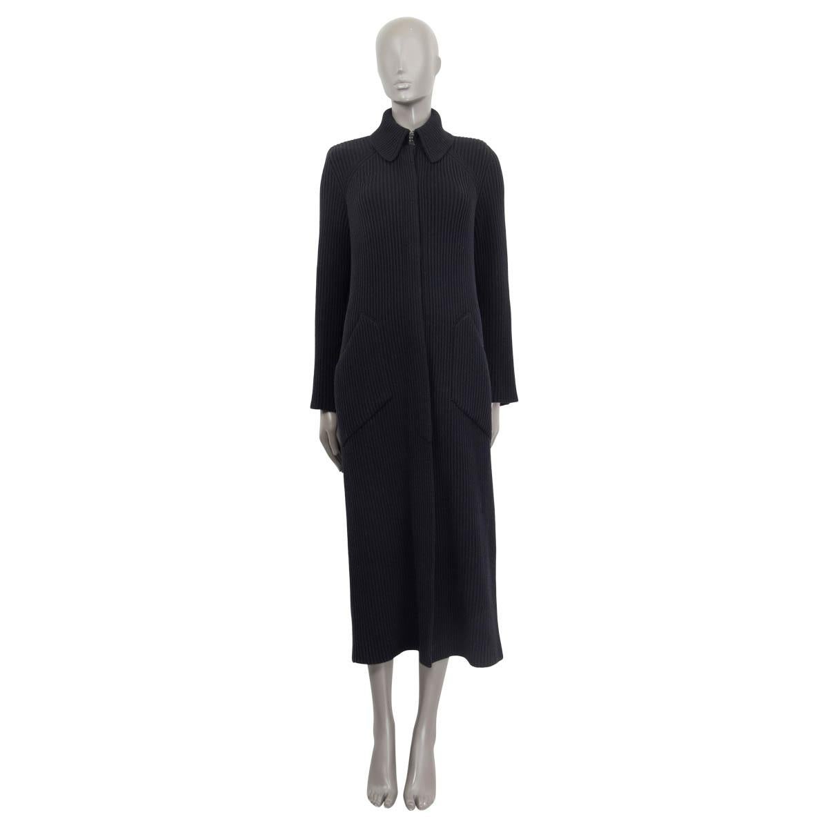 100% authentic Chanel Fall/Winter 2018 long knit coat in black wool (100%). Features buttoned cuffs and two slit pockets on the front. Has a slit on the back and padded shoulders. Opens with three hooks at the collar and eight concealed 'CC' buttons
