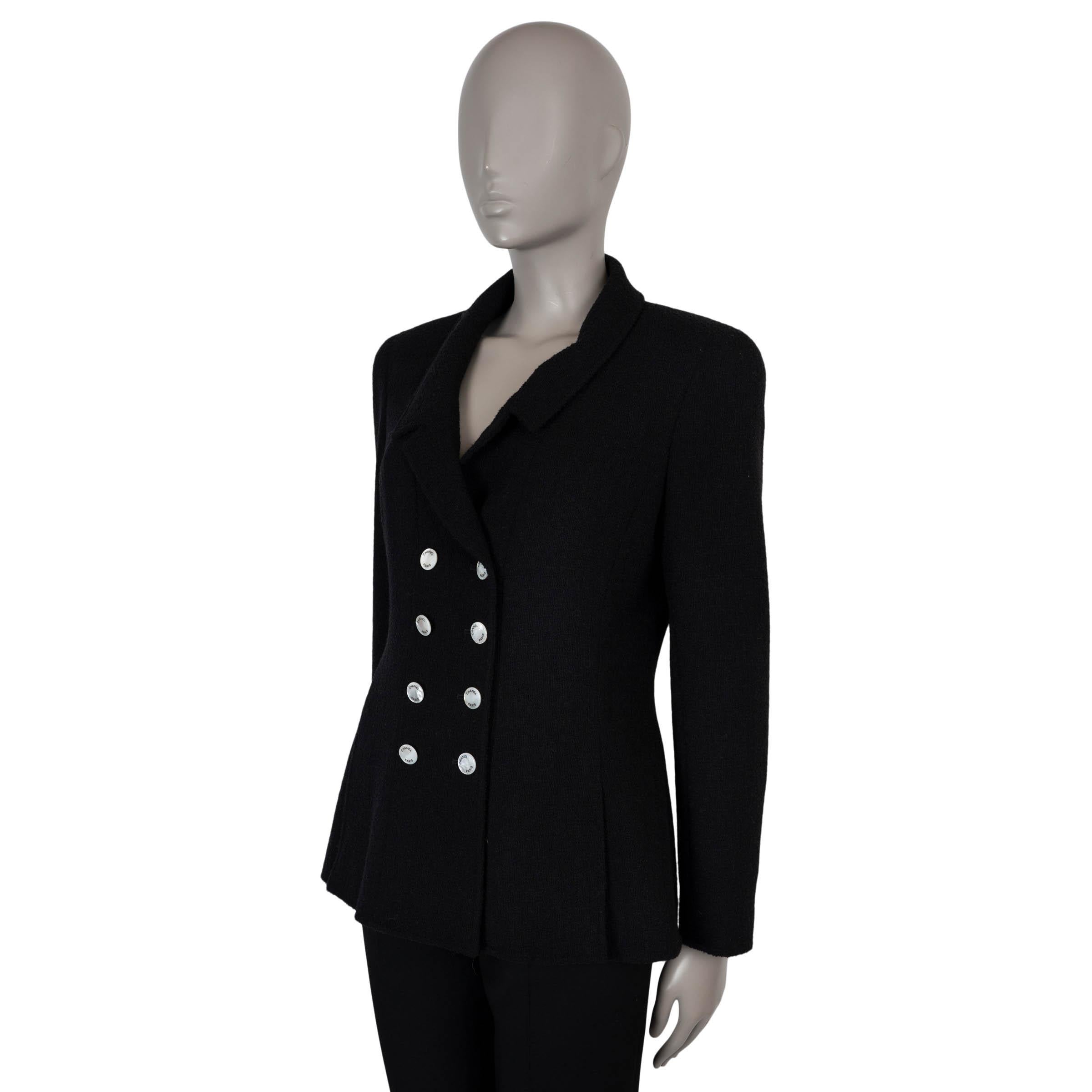 Questo blazer Chanel autentico al 100% è realizzato in spugna nera di lana (85%) e nylon (15%), combinando la consistenza con una struttura senza tempo. Presenta una silhouette aderente con revers dentellati, polsini con cerniera e una doppia fila