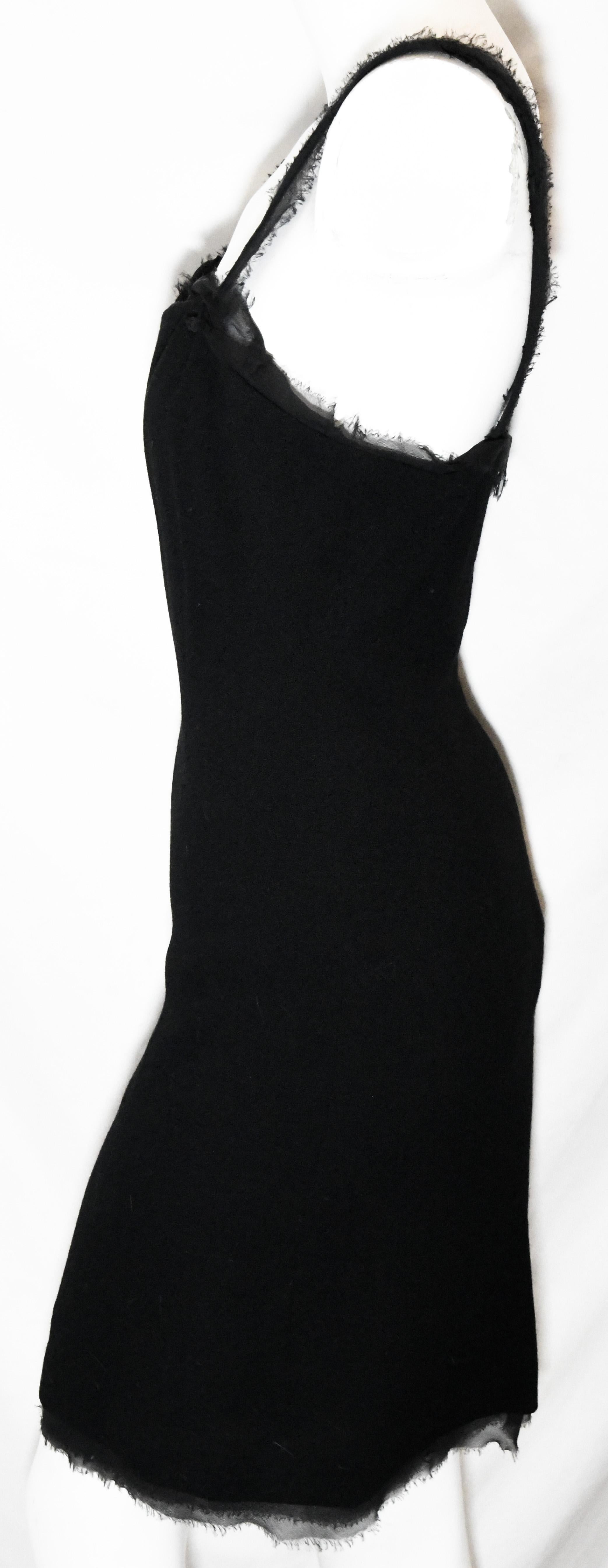 Chanel black wool dress sleeveless knee length dress with silk raw edge trim.  This dress is from the 2004 Spring collection.  On the strap on one side an interlocking CC accent.  A sleek design dress with the same silk raw edge trim on the hem.  