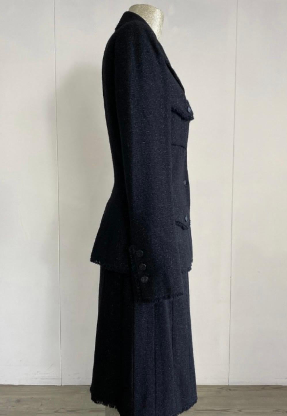 Chanel Suit, Jacket + skirt.
French size 36, therefore Italian 40.
In black wool but with a shiny twist.
jacket measurements: shoulder 42, sleeve 60cm, chest 40cm, length 60cm, skirt, 
Skirt measurements: waist 34cm, hips 45cm, length 55cm, in very