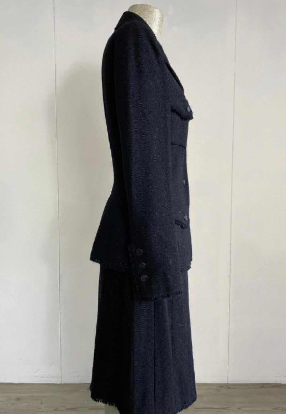 Chanel Anzug, Jacke + Rock.
Französische Größe 36, also italienische 40.
Aus schwarzer Wolle, aber mit einem glänzenden Twist.
Maße der Jacke: Schulter 42, Ärmel 60cm, Brust 40cm, Länge 60cm, Rock, 
Maße des Rocks: Taille 34cm, Hüfte 45cm, Länge