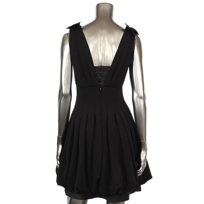 Chanel sleeveless knee-length cocktail dress in back wool (100%) with top and bottom part in black silk (100%). Opens with four rhinestone buttons and a hidden zipper on the back. Lined in silk. Has been worn and is in excellent condition.

Tag Size