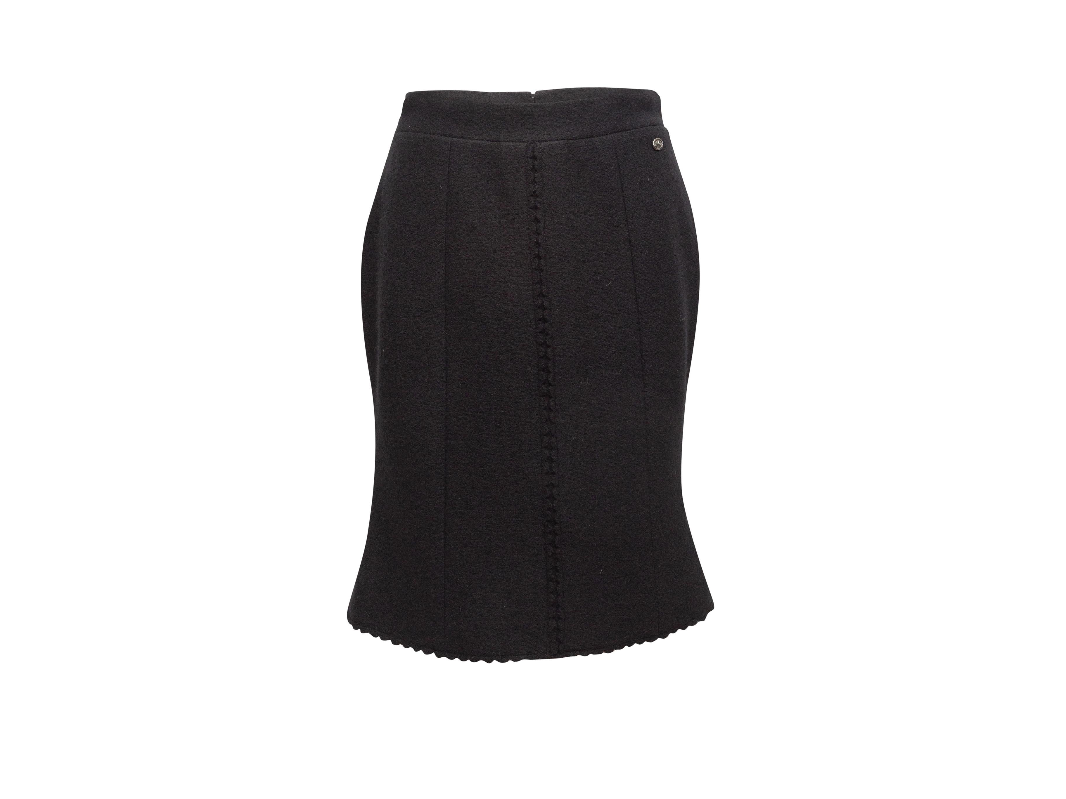 Product details: Black wool knee-length skirt by Chanel. Scalloped edges. Zip closure at center back. Designer size 40. 31