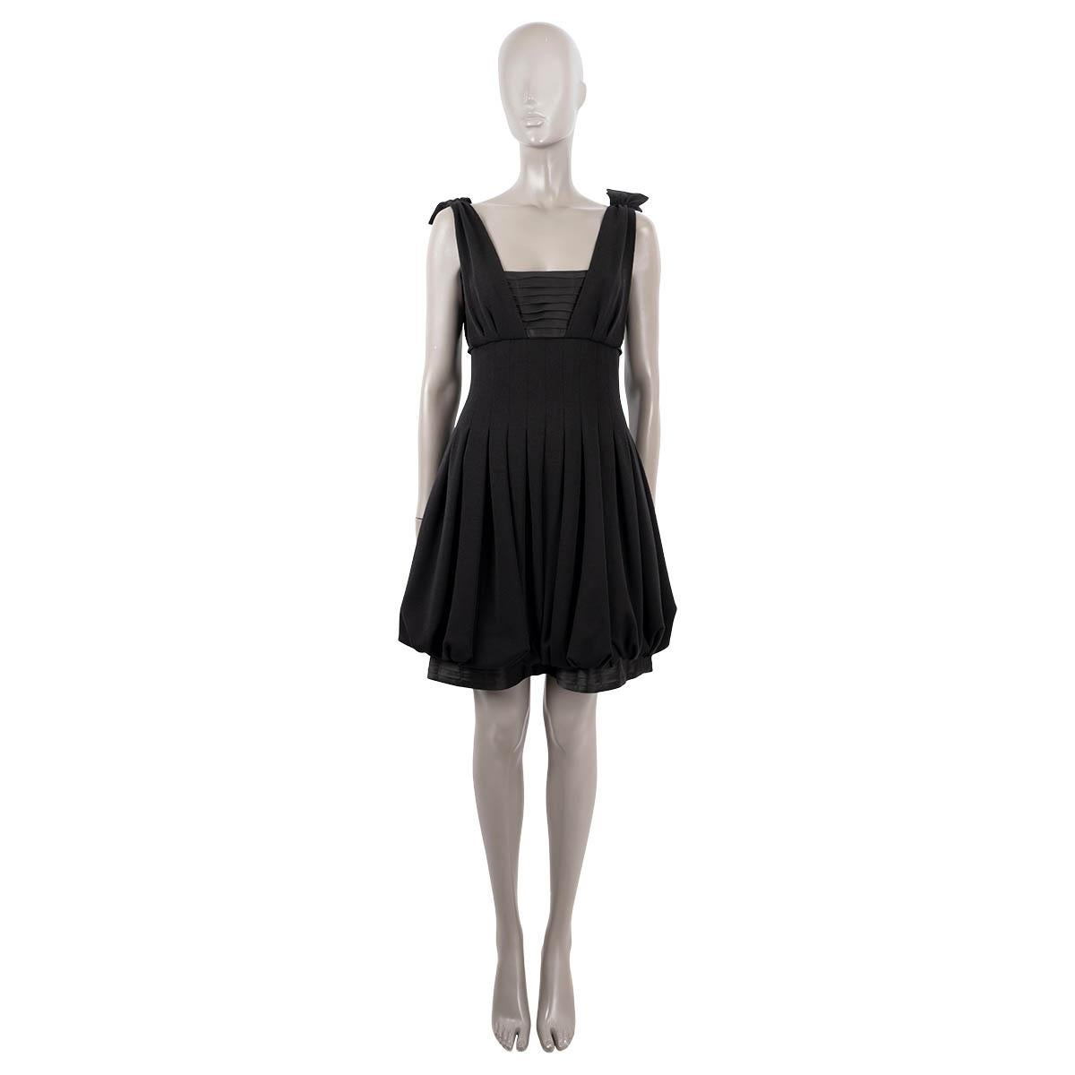 100% authentic Chanel sleeveless knee-length cocktail dress in back wool (100%) with top and bottom part in black silk (100%). Opens with four rhinestone buttons and a hidden zipper on the back. Lined in silk. Has been worn and is in excellent