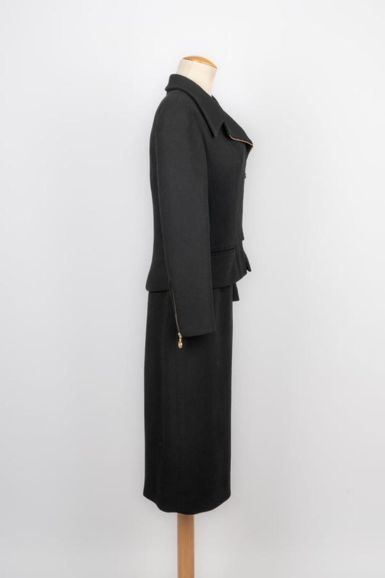 Chanel - (Made in France) Ensemble en laine noire composé d'une veste et d'une jupe, avec métal doré et doublure en soie. Taille 38FR indiquée.

Informations complémentaires : 
Condit : Très bon état.
Dimensions : Veste : Largeur des épaules : 39 cm