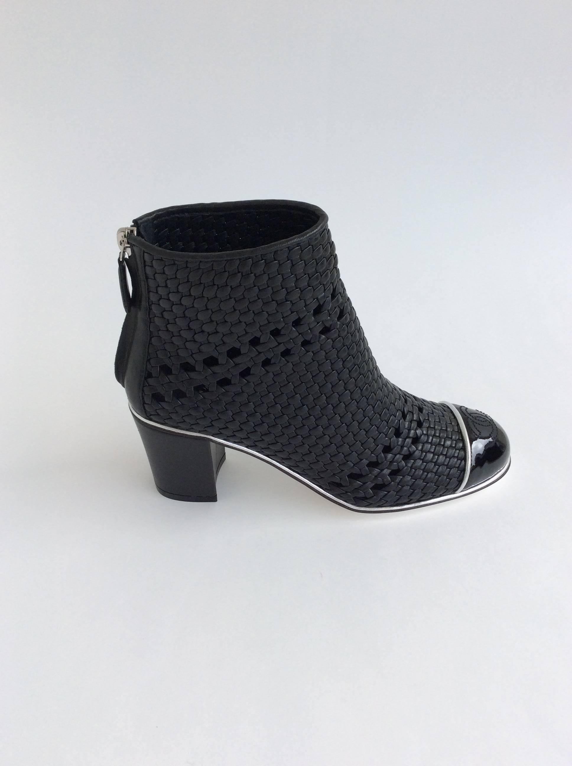 Chanel black woven leather booties with black patent leather “CC” on toes, silver trim throughout and chunky leather heel. Zippered closure at back. 

Sizing: Fr37.5, Us7.5

Heel height: 2.5 inches 