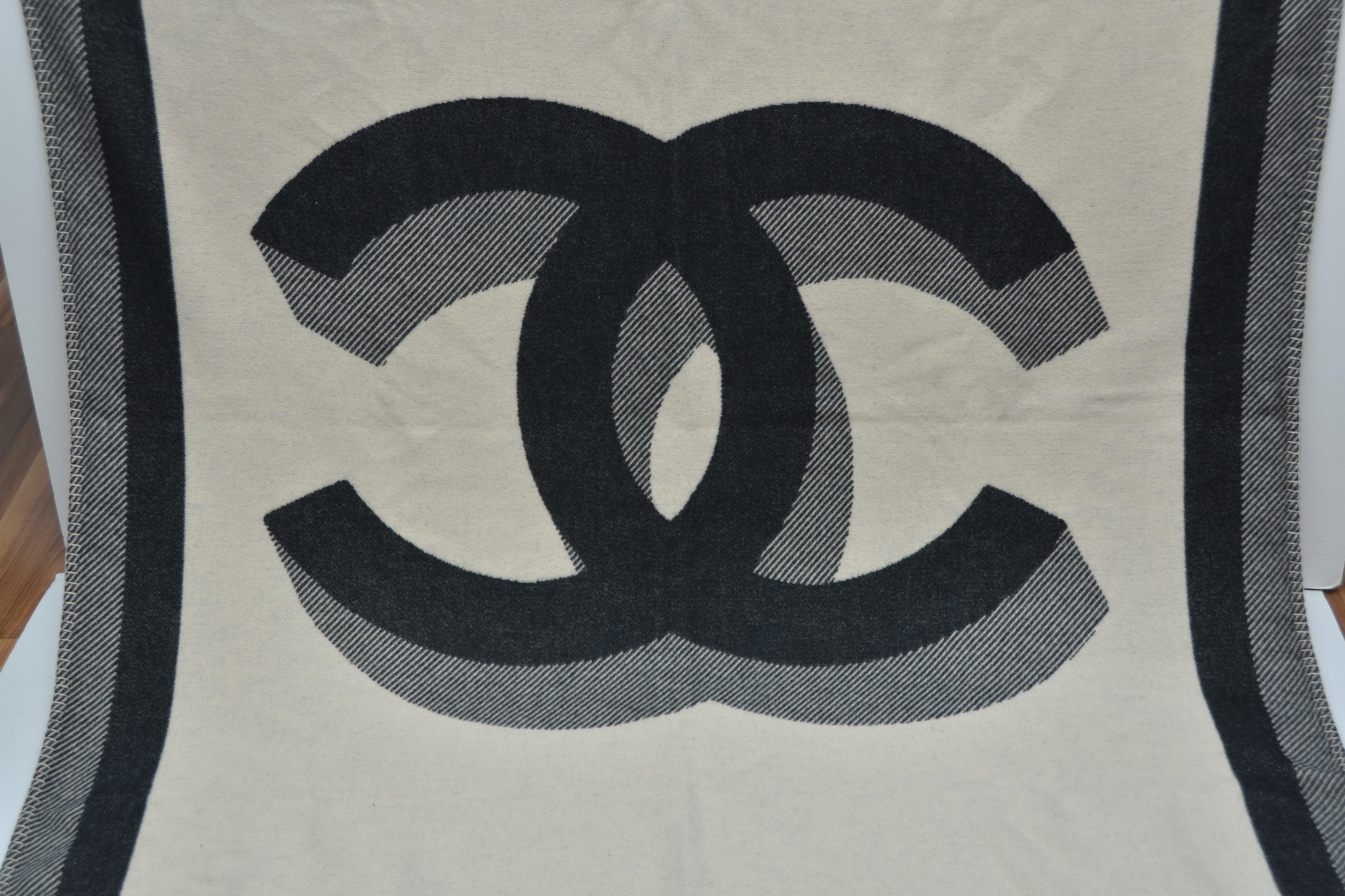 Tapis, jeté ou couverture de voyage Chanel
Neuf avec sac à poussière Chanel et étiquettes
Deux côtés différents avec un grand CC 
Mesure approximative : 74' X 55