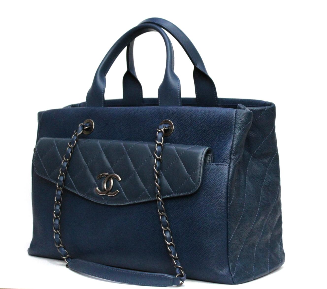 Chanel shopper bag made of navy blue hammered leather. The bag has a double handle but also a double chain to ensure it is worn on the shoulder or carried by hand. Internally it is divided into two compartments plus a central zip pocket. On the