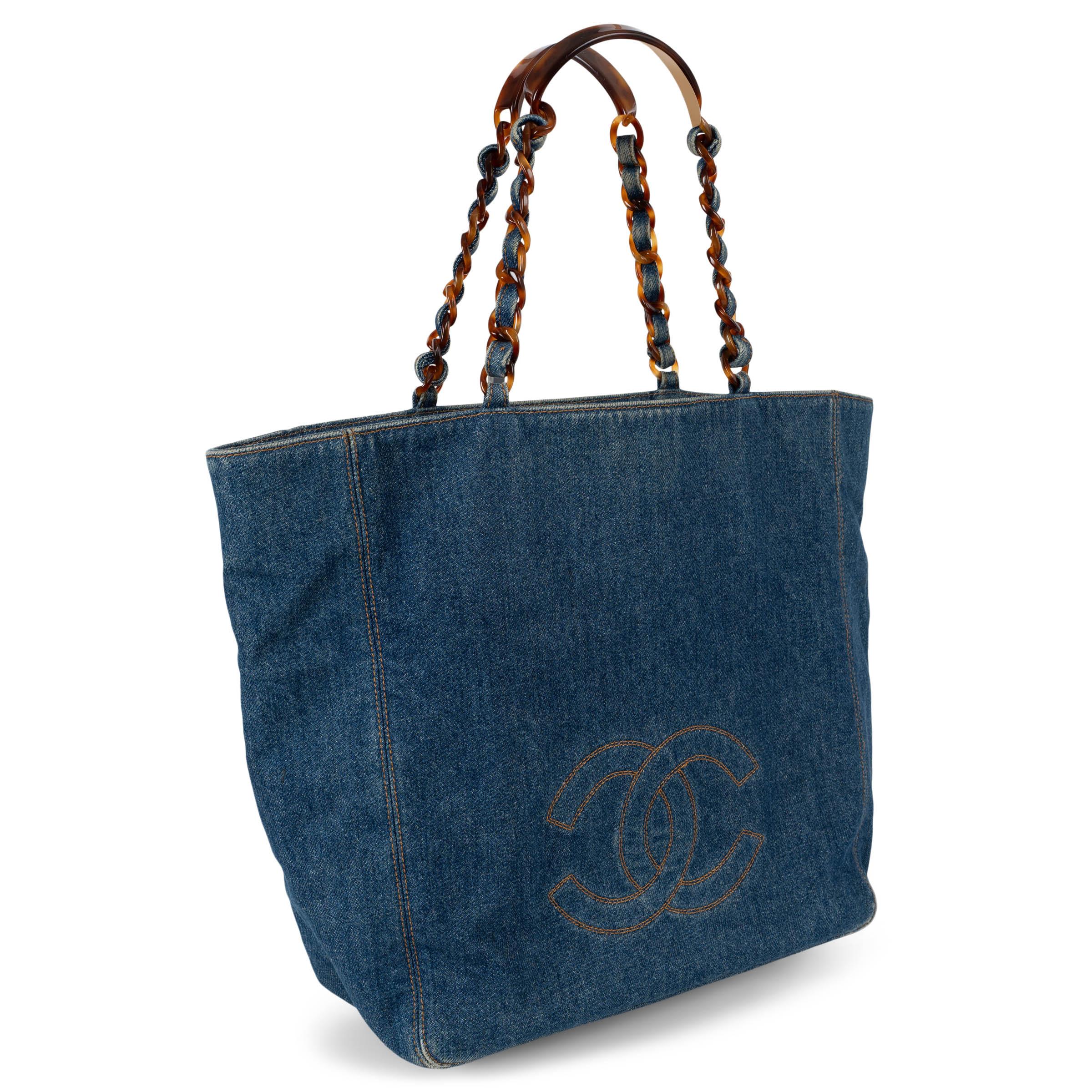 This 100% authentic Chanel shopper in blue denim offers a casual yet elevated take on a house classic. Featuring contrasting orange stitching and the iconic CC logo on the front, it’s detailed with denim-interwoven tortoise chain straps for a