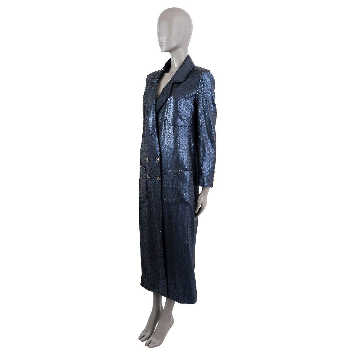 100% authentic Chanel double breasted notch lapel sequin coat in midnight blue polyester (100%) with black silk (100%) lining. The design features four front patch pockets, four CC embellished front buttons and three on each cuff. Each sequin is
