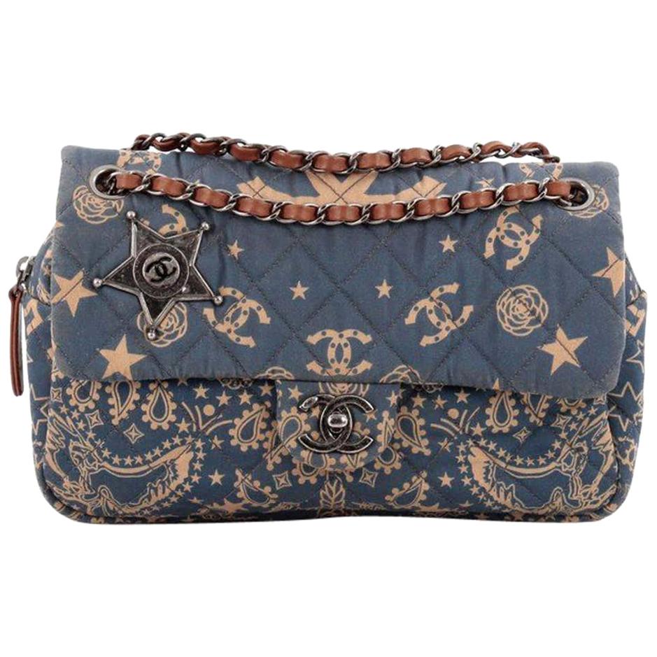 This authentic Chanel Paris-Dallas Bandana Flap Bag Quilted Canvas Medium is from the brand's 2013/2014 Paris Dallas Metiers D'art Bag Collection. 
Crafted from blue quilted canvas with a motif of paisley, camellias and stars print, this flap bag