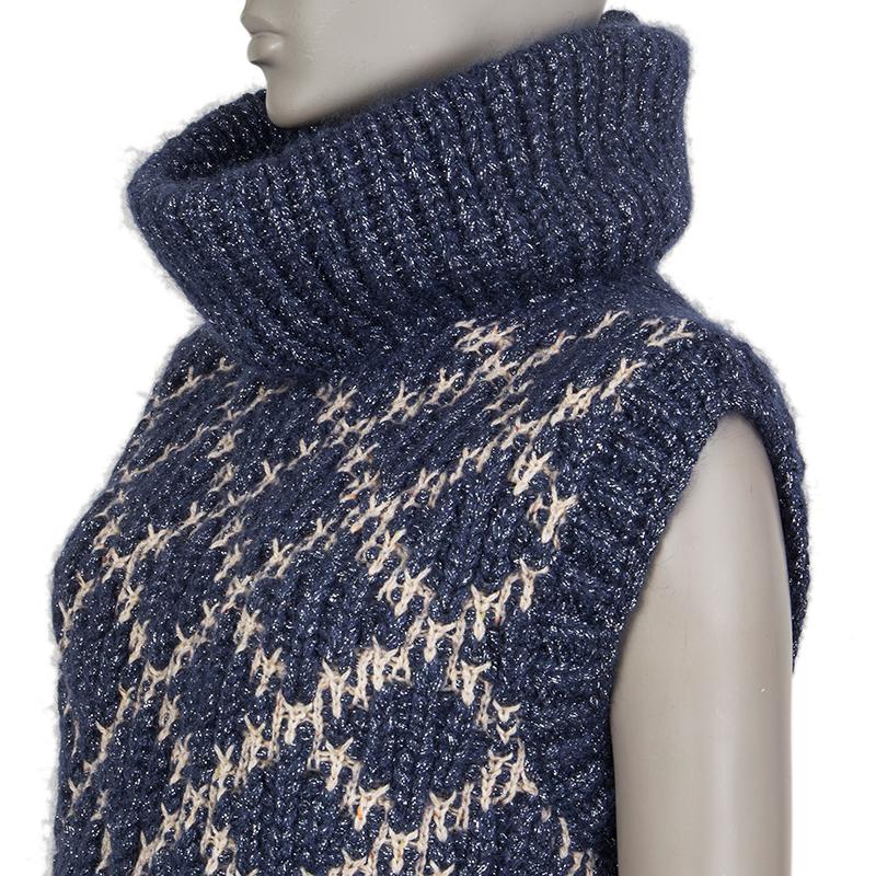 Chanel chunky knit lurex sweater in navy, beige and off-white mohair (47%), nylon (16%), rayon (15%), wool (14%) and polyester (8%) with a turtleneck. Closes with chain-detail-buttons at the back. Has been worn and is in excellent condition.

Tag