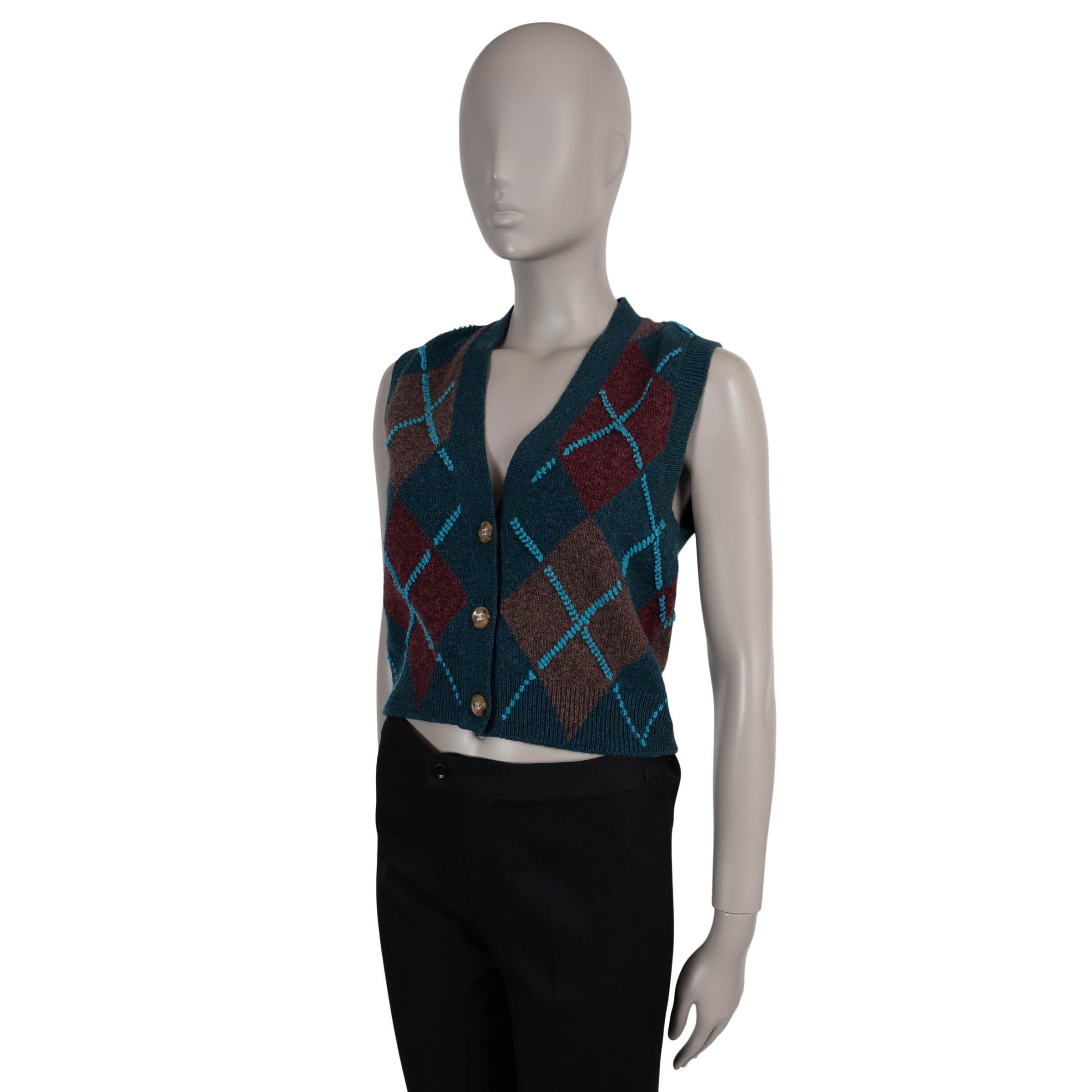 This 100% authentic Chanel cardigan vest in dark blue cashmere (with 1% elastane and 1% polyamide) is a cozy yet polished layering piece. Featuring an argyle pattern in brown, camel, and turquoise, it’s designed with a classic fit, V-neckline, and