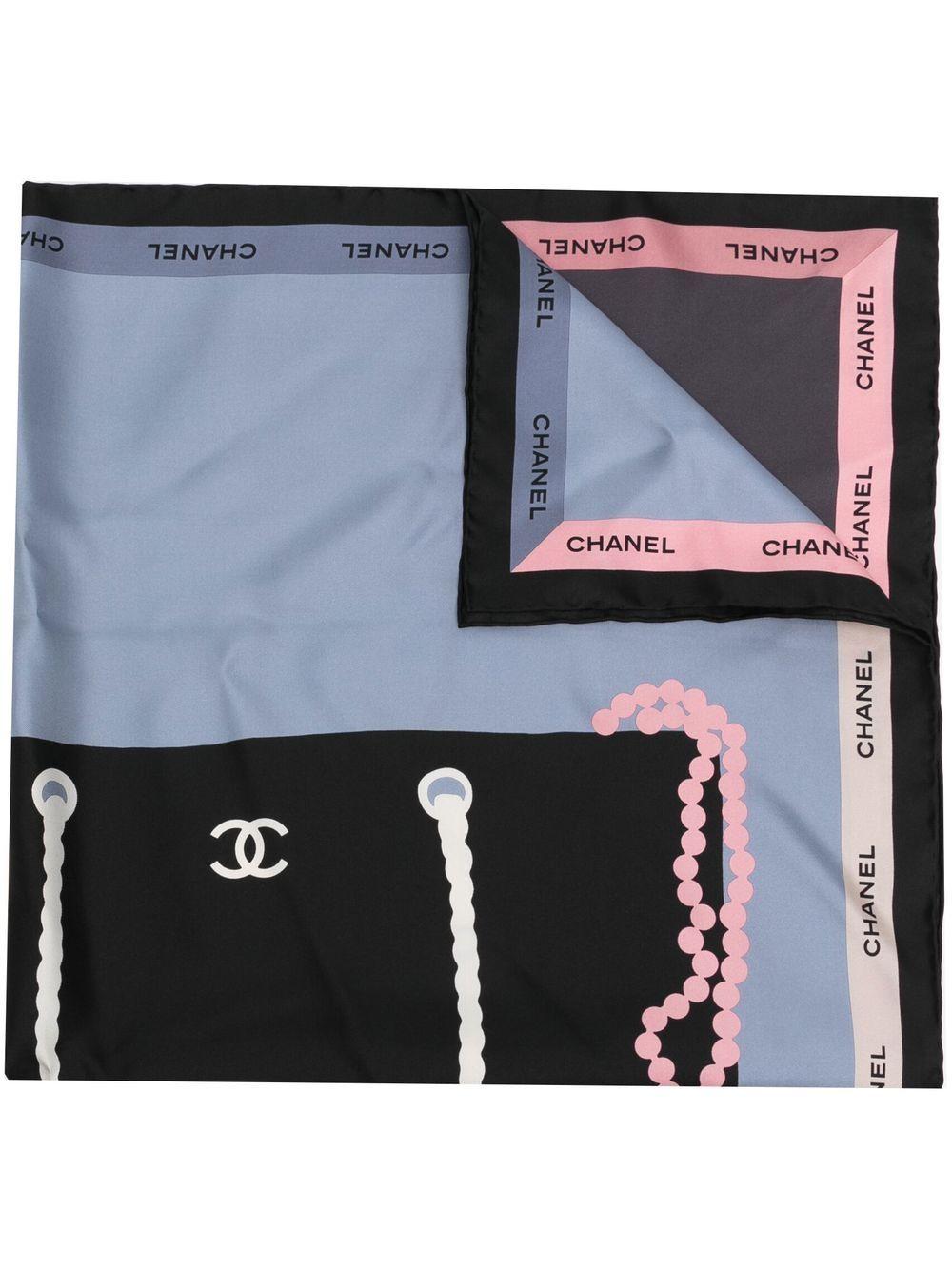 Designed with a large handbag motif, representing Chanel's iconic bags, this pre-owned silk scarf has been designed in the shades of black, white, blue and red. Finished with a border of Chanel's famous logo, wear it around your neck or twisted