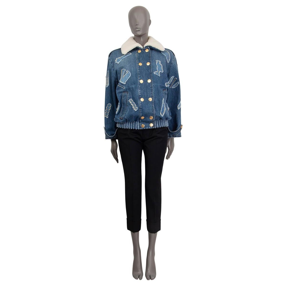 100% authentic Chanel Metier's d'Art 2018/19 denim bomber jacket in washed blue cotton (100%). Features a shearling collar, epaulettes at the cuffs and two side slit pockets on the front. Has epaulettes at the shoulders and patches with a golden and