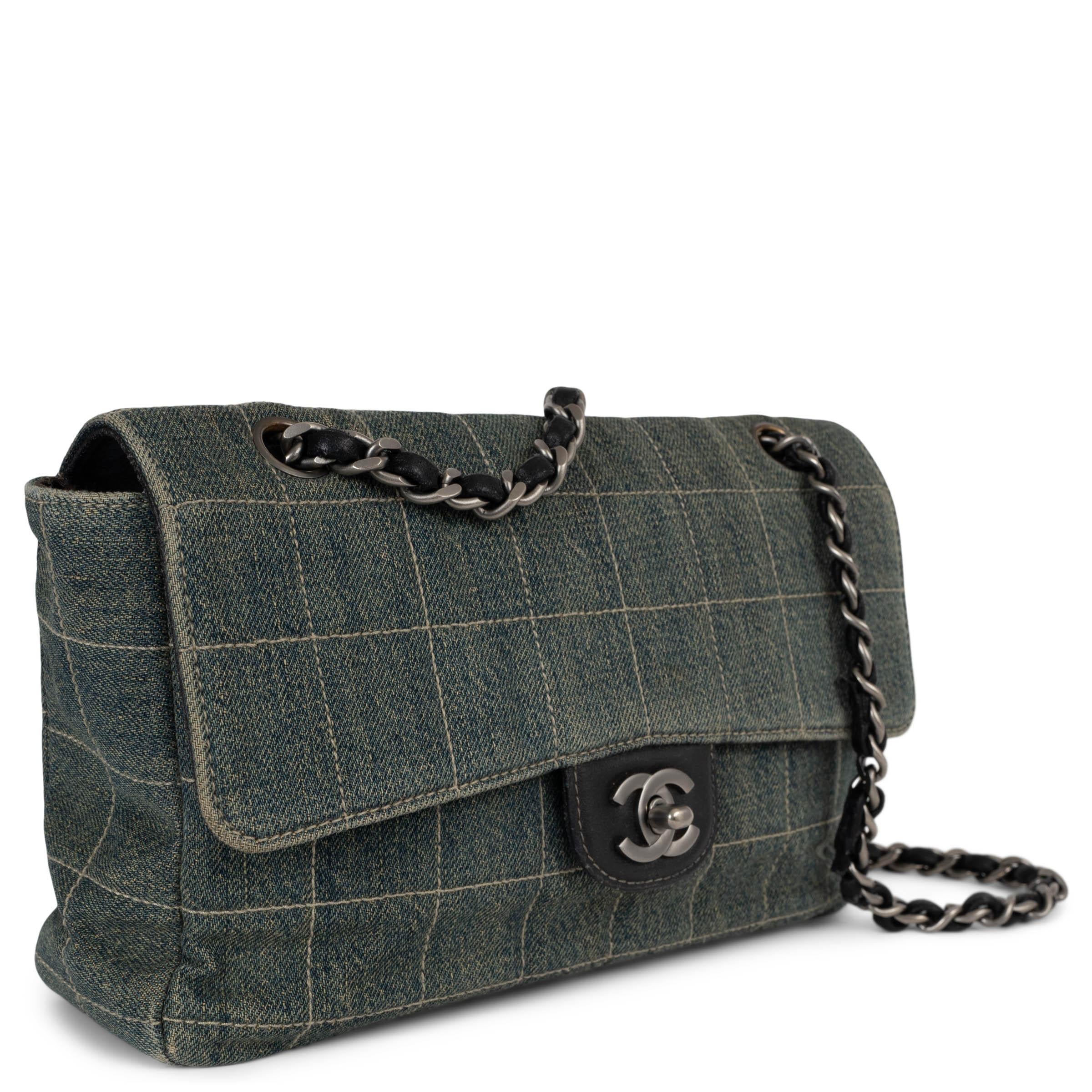 This 100% authentic Chanel Chocolate Bar Medium Flap Bag is crafted from classic blue denim with the signature chocolate bar quilted pattern, offering a modern yet timeless aesthetic. Accented with matte silver-tone hardware and a signature CC