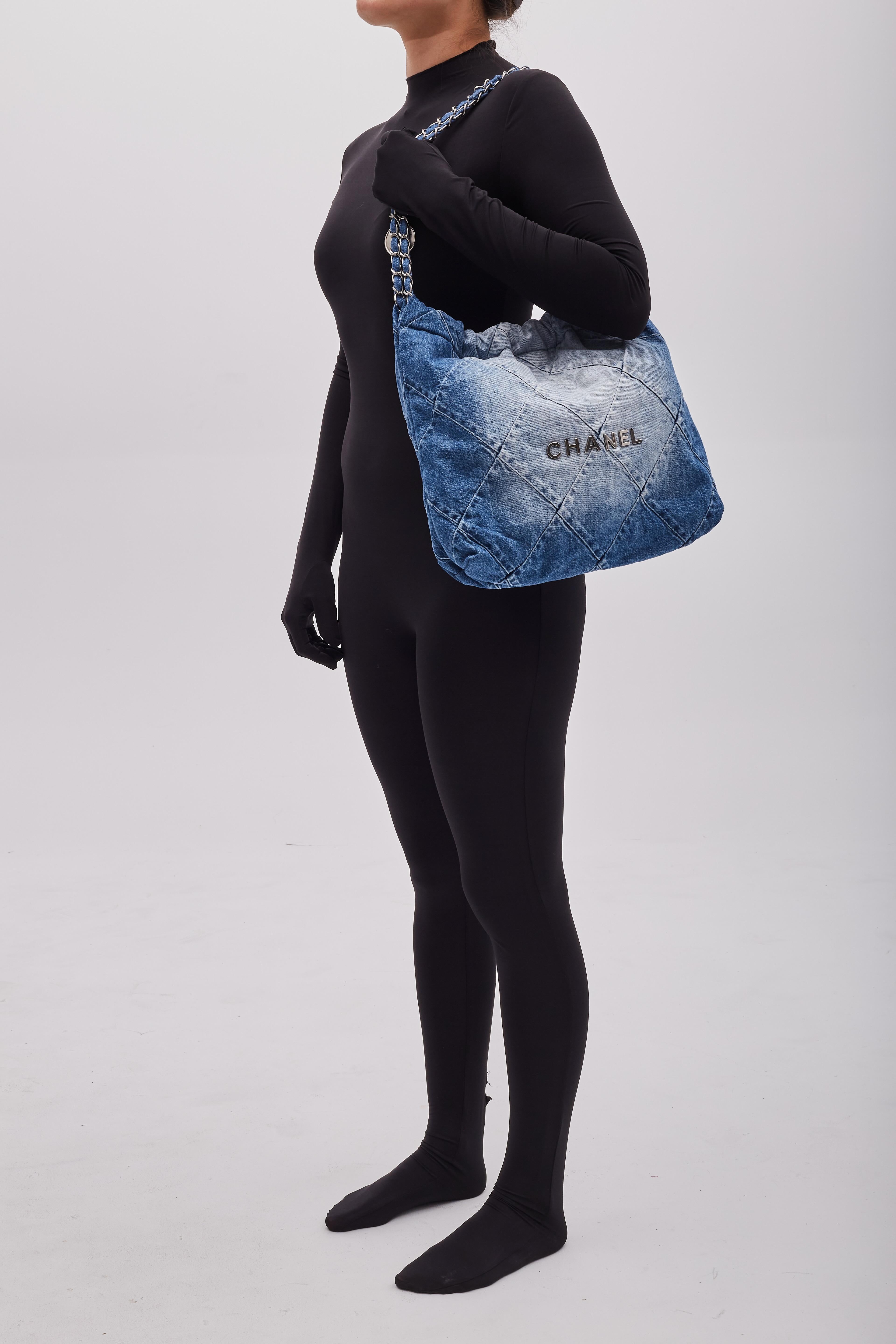 This bag is made of diamond-stitched blue denim with silver tone hardware. The bag features denim threaded chain shoulder straps, a matching Chanel logo on the front and a hanging logo charm. The drawstring shoulder straps and magnetic snap closure