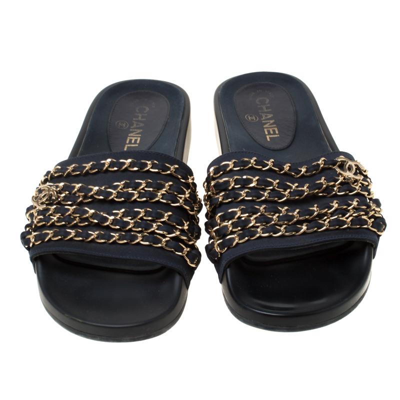 Stay comfortable throughout the day with minimal and effortless luxury in these Chanel Marine slides. Crafted in blue fabric front strap and a black rubber sole, these slides feature gold-tone chains woven with leather on the uppers.

Includes: The