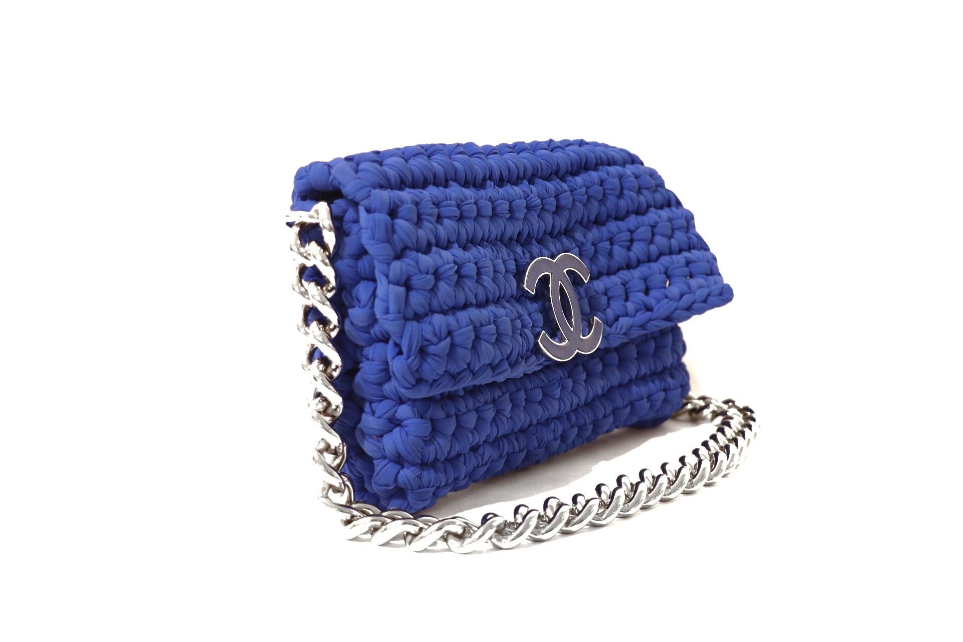 This authentic Chanel Blue Fancy Crochet Flap Bag is in excellent condition.  From the Cruise 2014 Collection, this uniquely textured piece adds a splash of color to any ensemble. 
Bright Cobalt Blue woven fabric bag has a leather interlocking CC