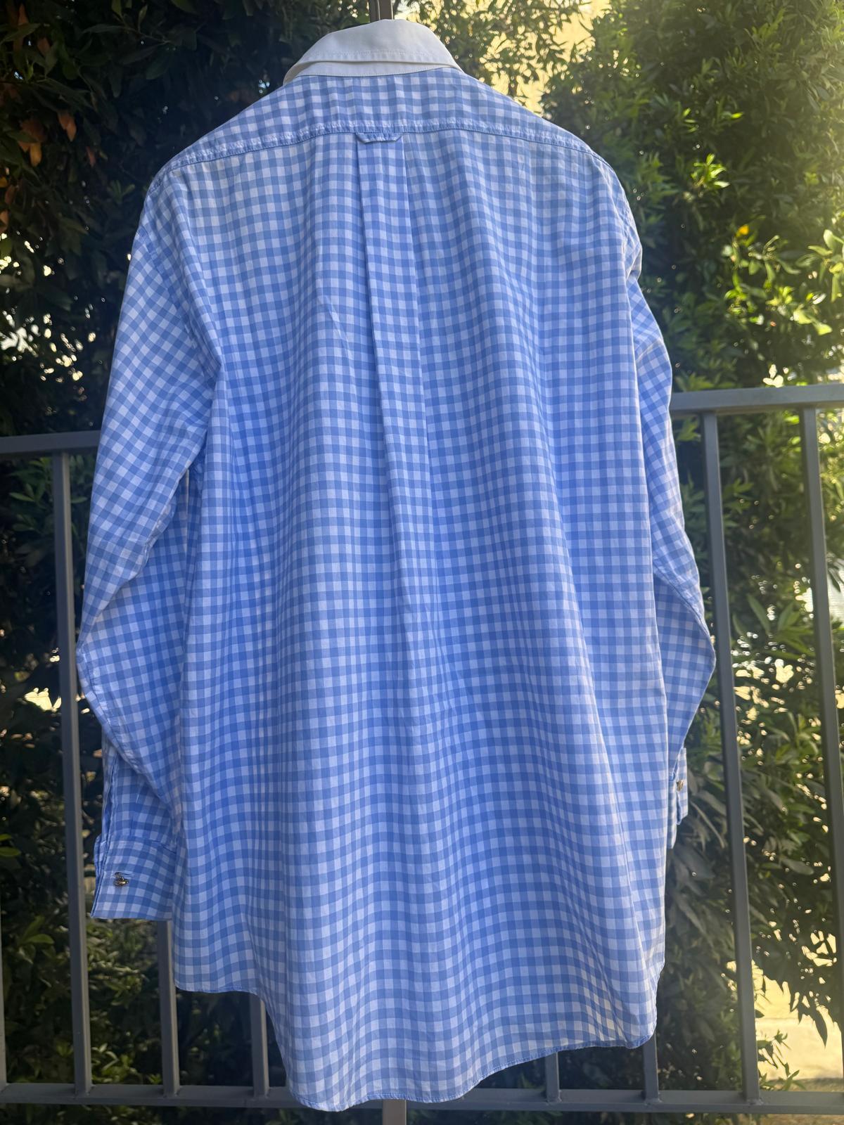 Chanel blue gingham button-down shirt with a white contrast collar and CC logo embroidery on the front pocket. 

Features gold-tone CC logo buttons. 

There is no size tag, so please refer to measurements:

	•	Shoulder to shoulder: approx. 48