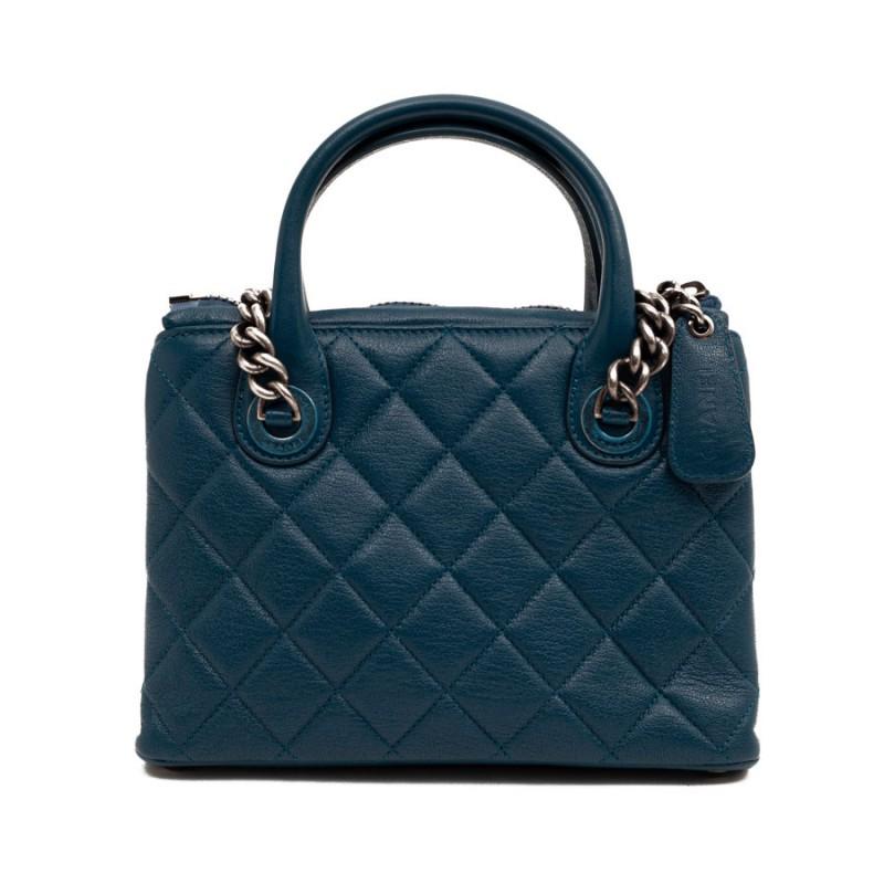 CHANEL blue bag
Limited series from Maison Chanel. Handbag carried by 2 handles or over the shoulder by two aged silver metal chains. On the jewelry, there are blue plastics (see photos).
It is in grained leather with 3 compartments, one of which is