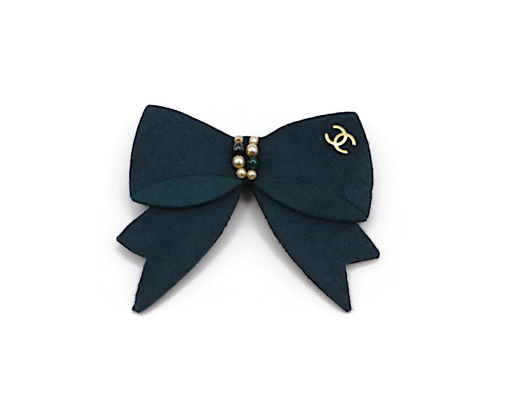 CHANEL green blue and green felt bow brooch embellished with faux pearls, beads and gold tone CC logo.

Fall 2002 Collection.

Marked CHANEL 02 A Made in France.

Indicative measurements : max. width approx. 7 cm (2.76 inches) / max. height approx.