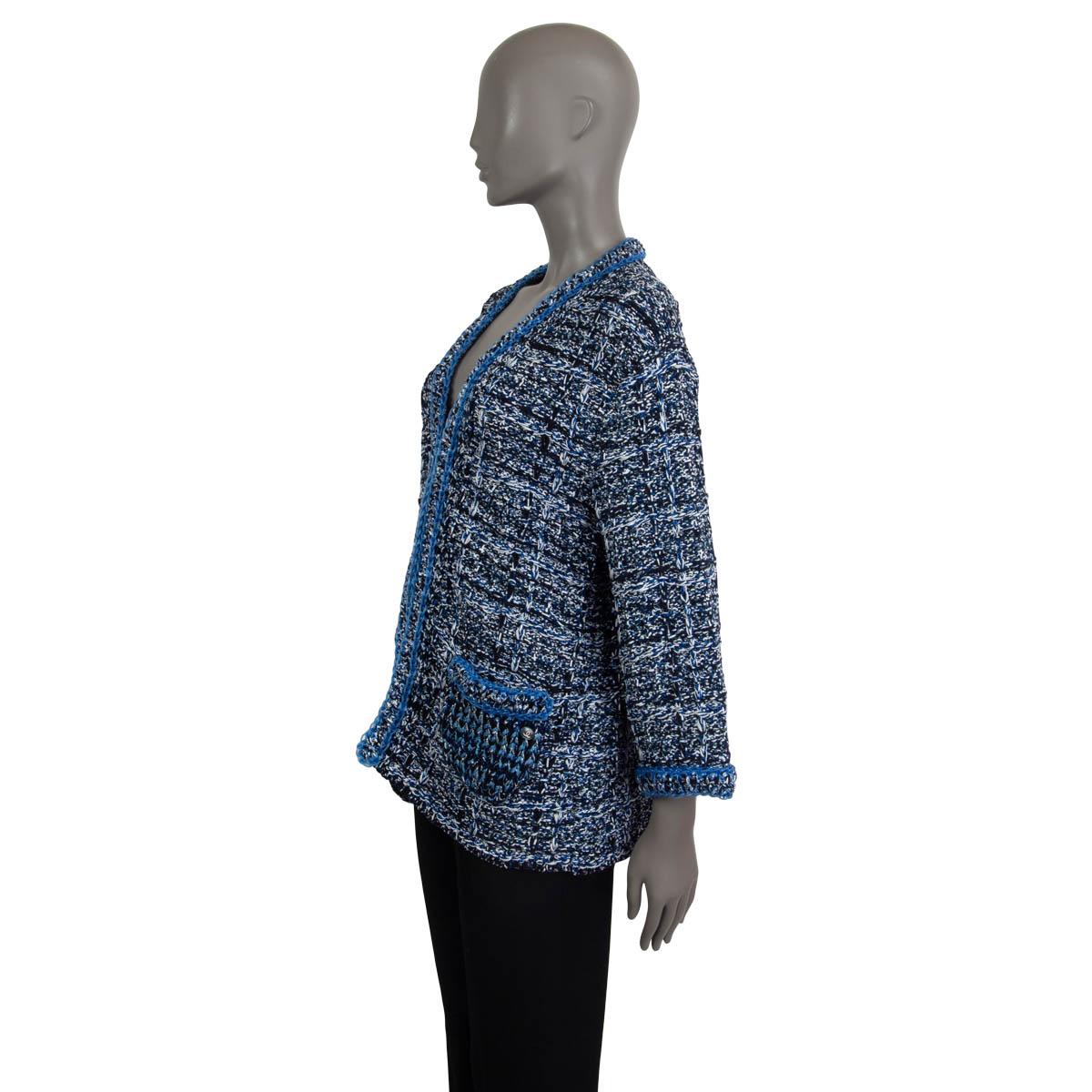 100% authentic Chanel crochet long sleeve cardigan in blue, black, white and grey cotton (100%). Embellished with lurex threads and a blue rubber chain on the cuffs, pockets and the collar. Comes with two slit pockets, one with CC logo on. Closes