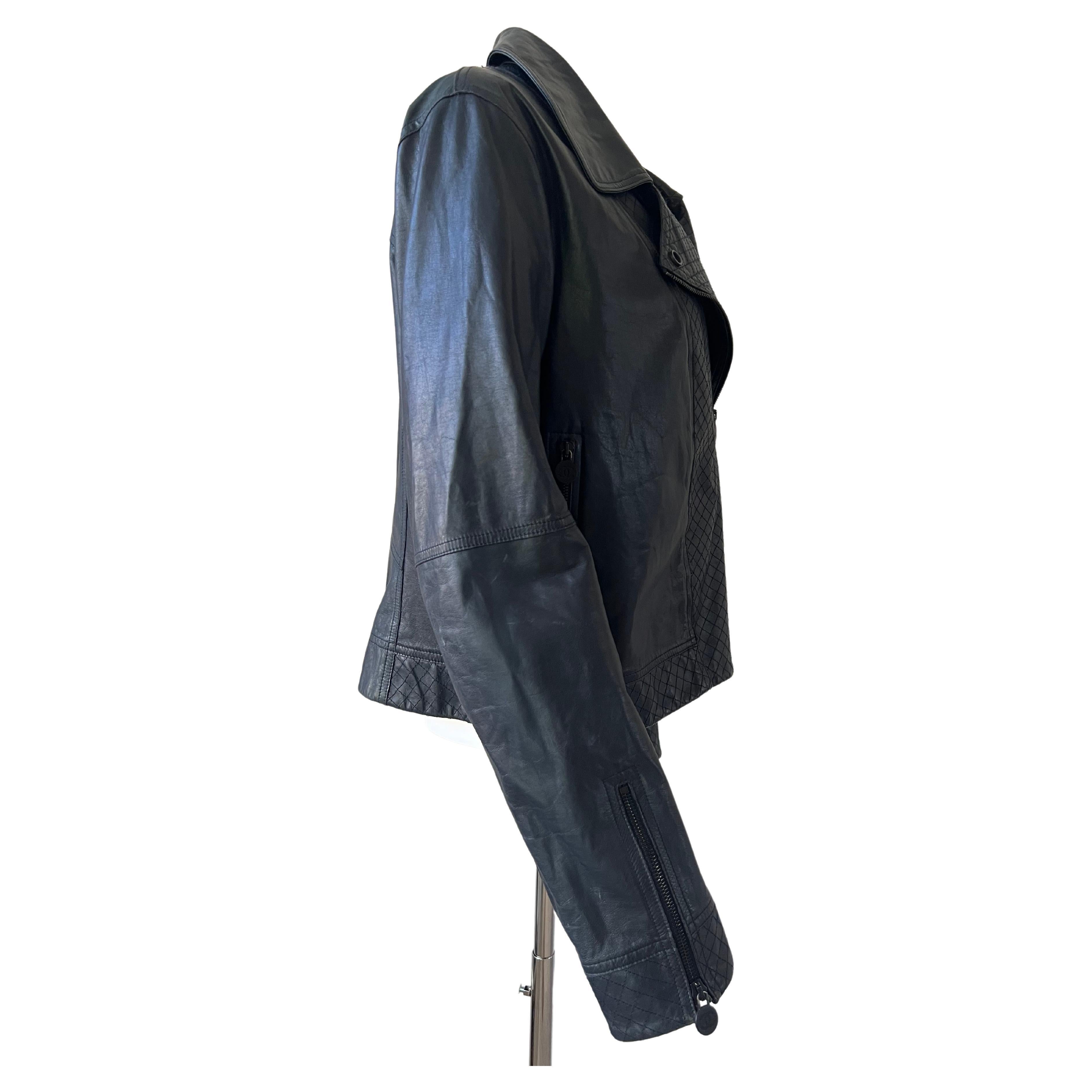 Prefecto en cuir bleu-gris, surpiqûres sur le devant. Fermeture éclair et pression avec le logo Chanel, fermeture éclair au bout de chaque manche. Double CC sur la manche gauche. Belle couleur et très bon style.