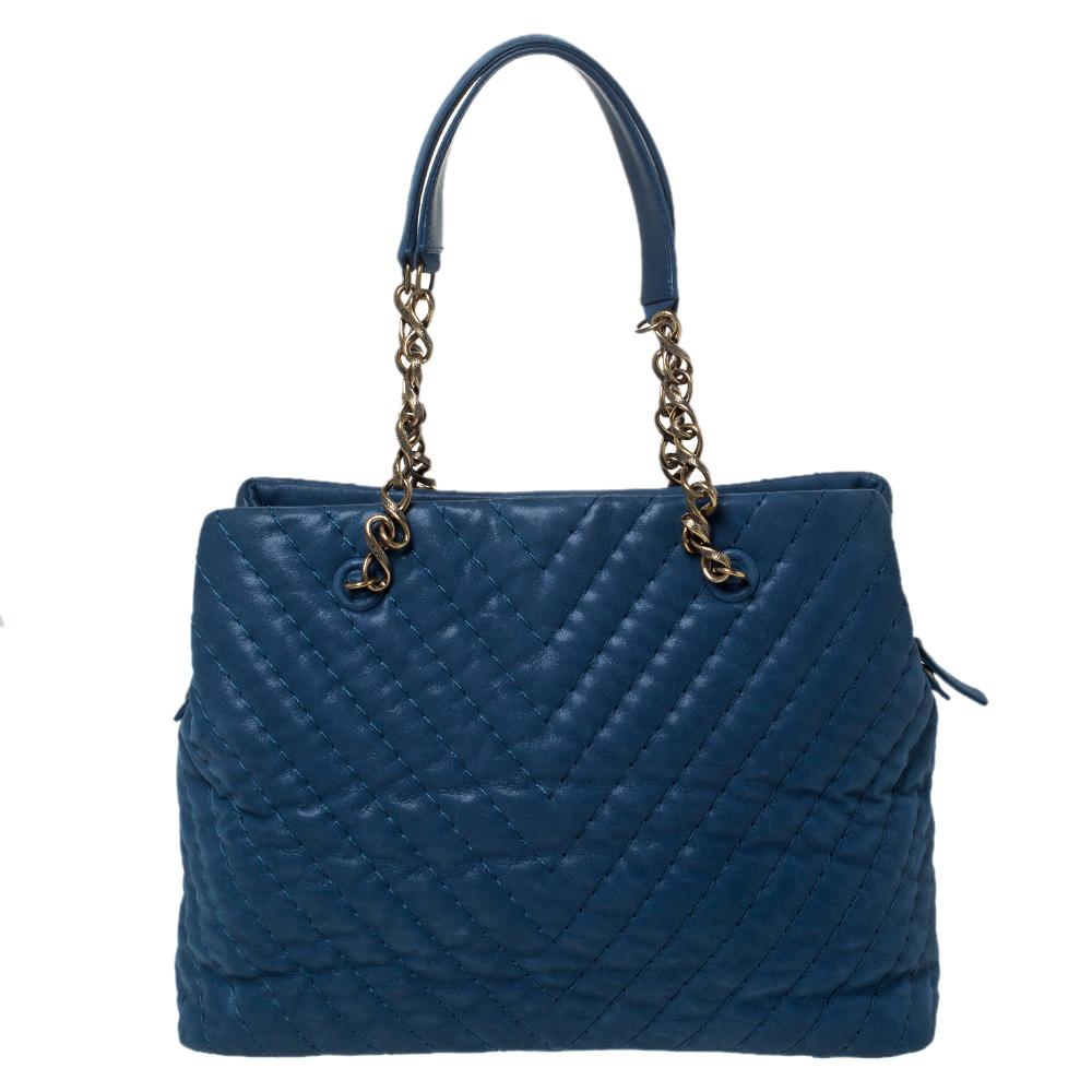 This bag from Chanel is a chic accessory that represents the brand's rich aesthetics and elegant designs. Crafted from blue iridescent leather, it has chevron quilting all over. This easy-to-carry bag comes with two handles and a spacious interior.