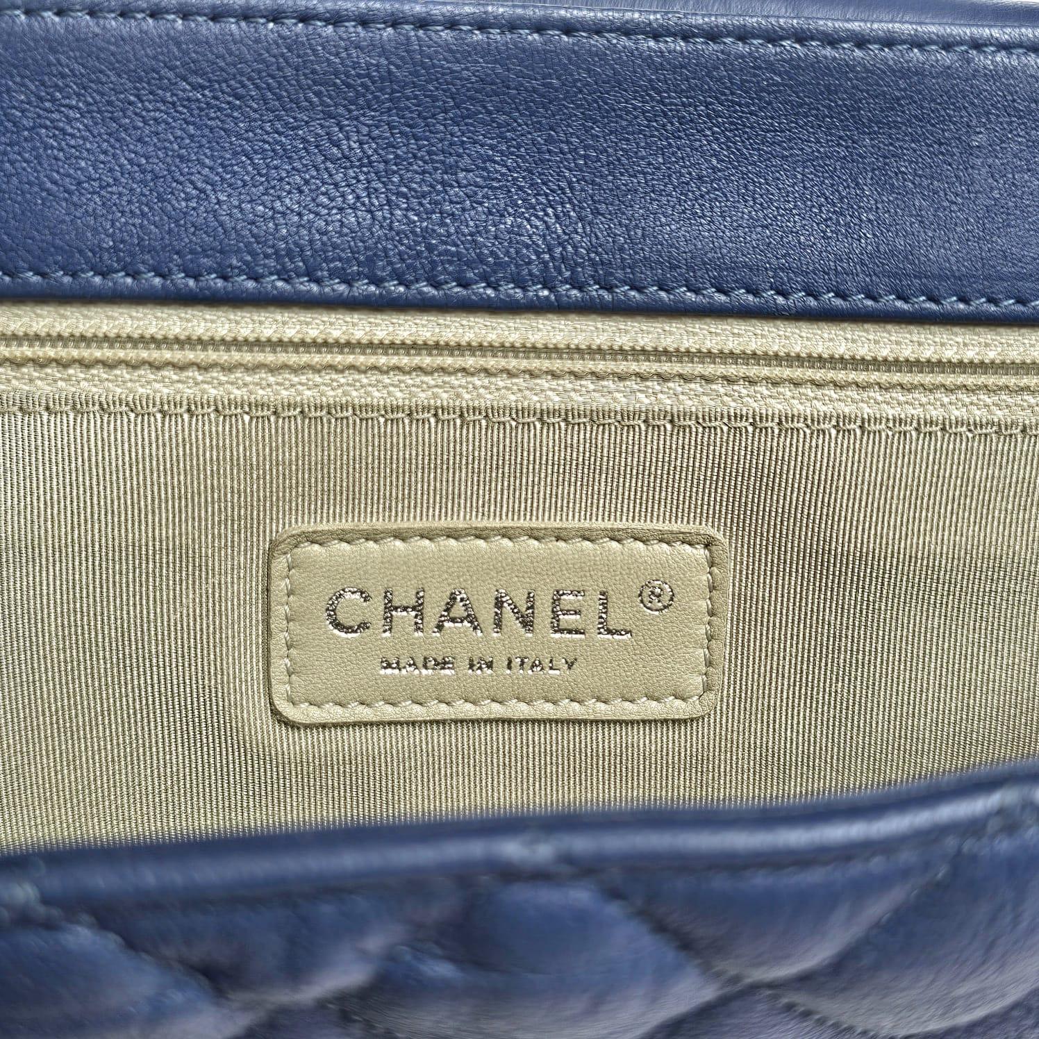 Magnifique sac à rabat avec chaîne, de couleur bleue. Des chaînes entrelacées s'enroulent autour du sac pour former une bandoulière. Légers frottements sur les coins. Série n° 15. Livré avec son holo, sa carte et son sac à poussière. 