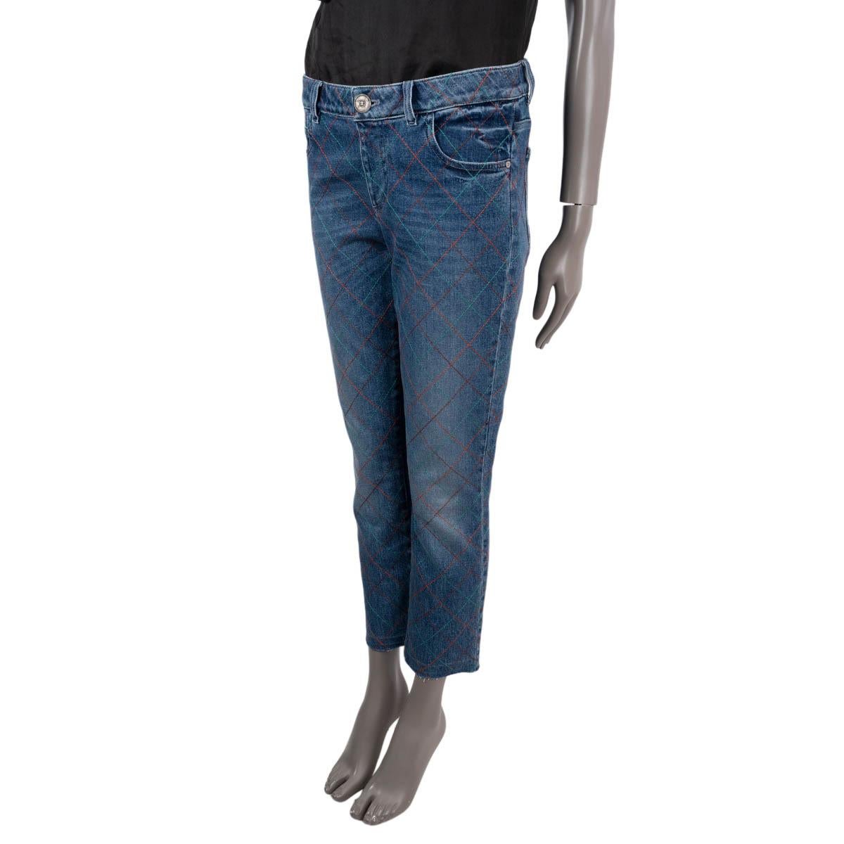 Jeans Chanel 100% authentique en denim bleu de coton (98%) et polyuréthane (2%) avec surpiqûres en orange, bordeaux et turquoise. Il est doté de poches fendues sur le devant et au dos et de passants de ceinture. Il s'ouvre par une fermeture à