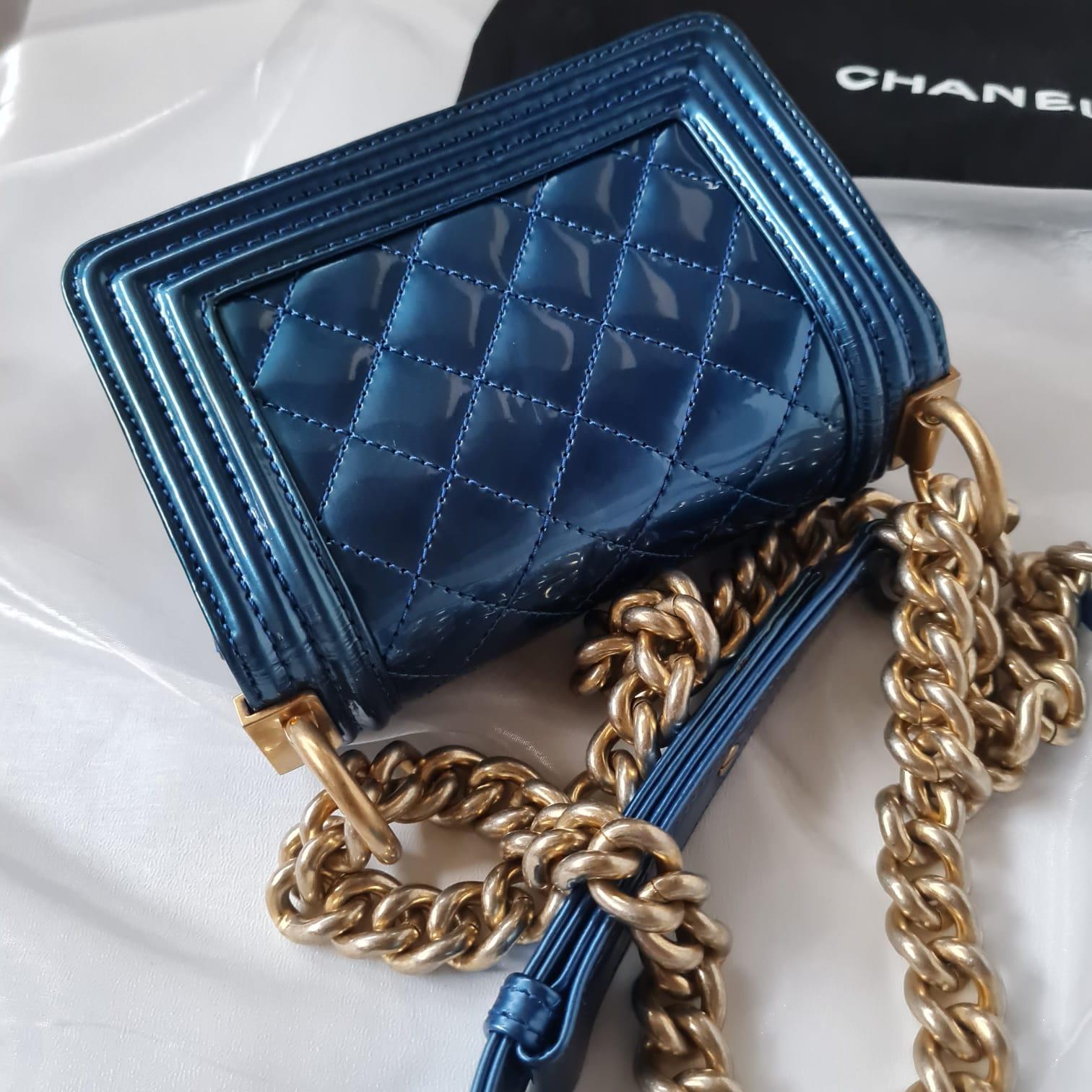 Cette édition limitée du sac Chanel Mini Blue Patent Boy Bag est en bon état. La liste comporte de belles pièces de quincaillerie complexes. Léger jaunissement sur toute la surface du brevet avec des marques sombres visibles sur le fond du sac comme