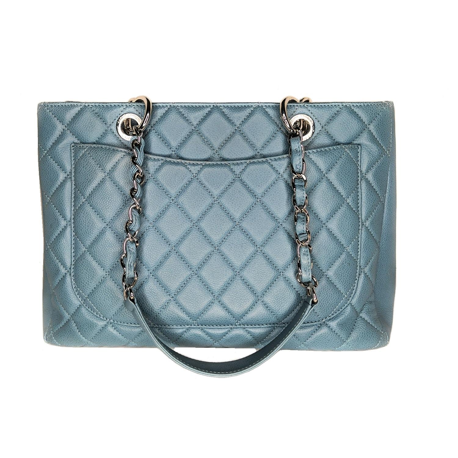 This stylish tote is crafted of diamond-quilted caviar leather in blue. This shoulder bag features leather-threaded polished silver chain-link shoulder straps with shoulder pads, a quilted Chanel CC logo on the front, and a flat pocket on the rear.