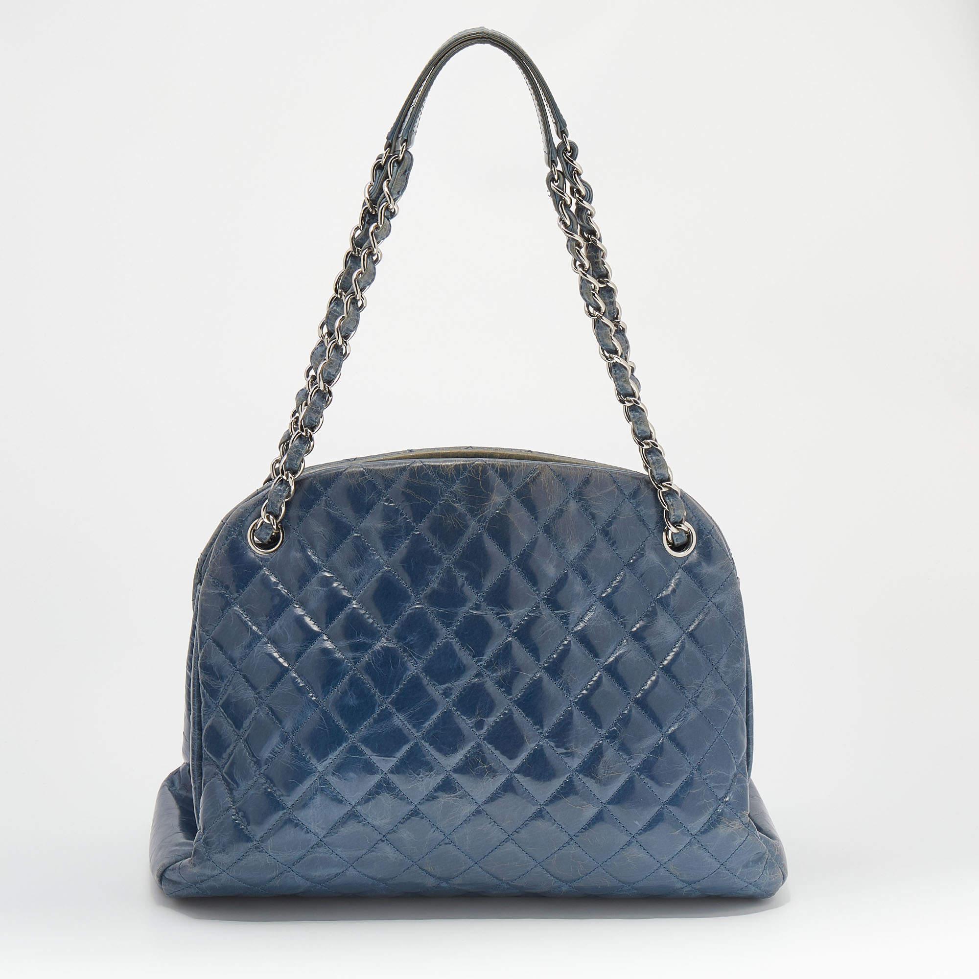 This Just Mademoiselle Bowling bag from Chanel is full of charm and elegance. It has been crafted from quilted crackled leather and features a lovely shape and design. It is equipped with two chain handles and a well-sized fabric interior to keep